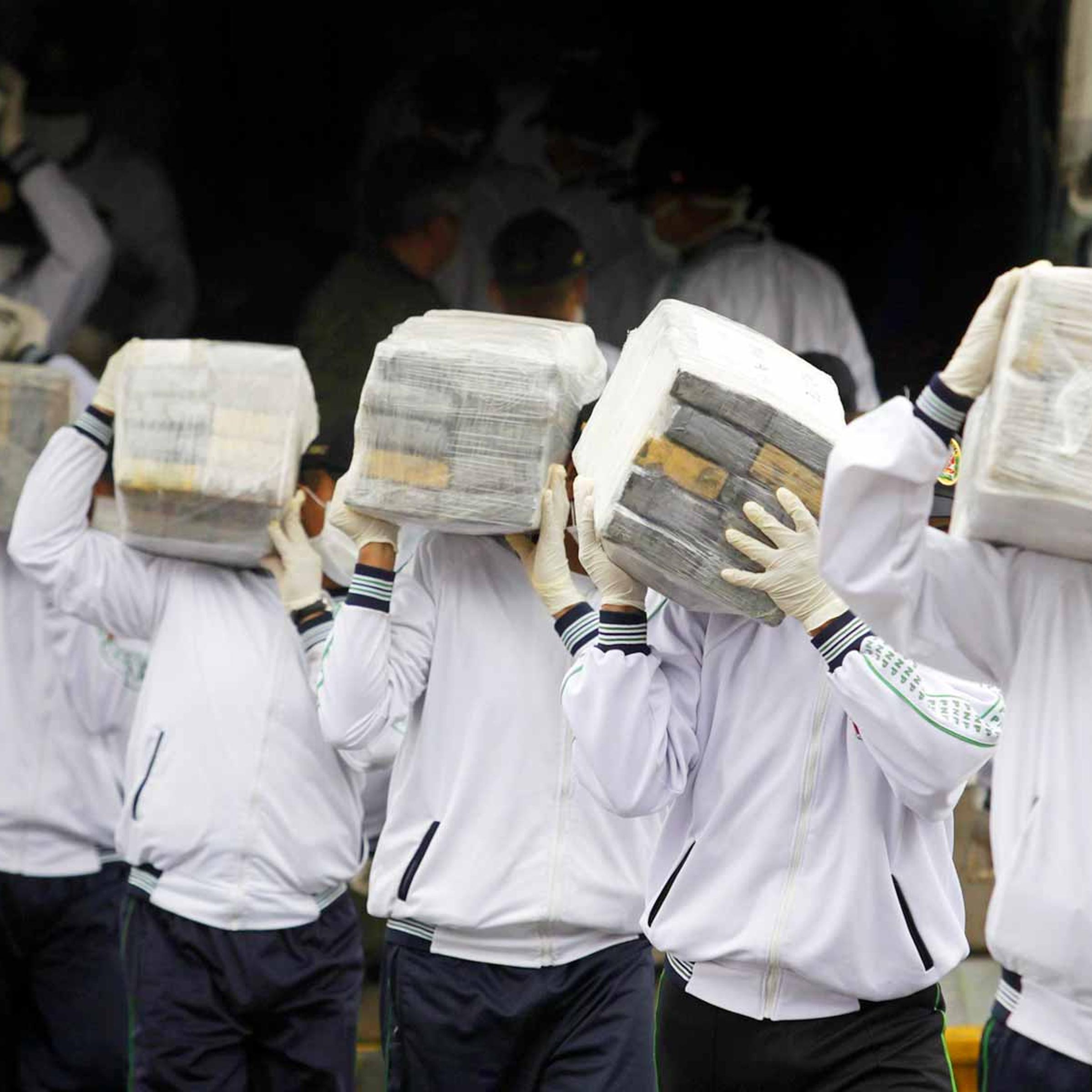 Peruvian police with cocaine seized in a recent drug raid.
A record 6.7 million metric tons was taken at the end of August