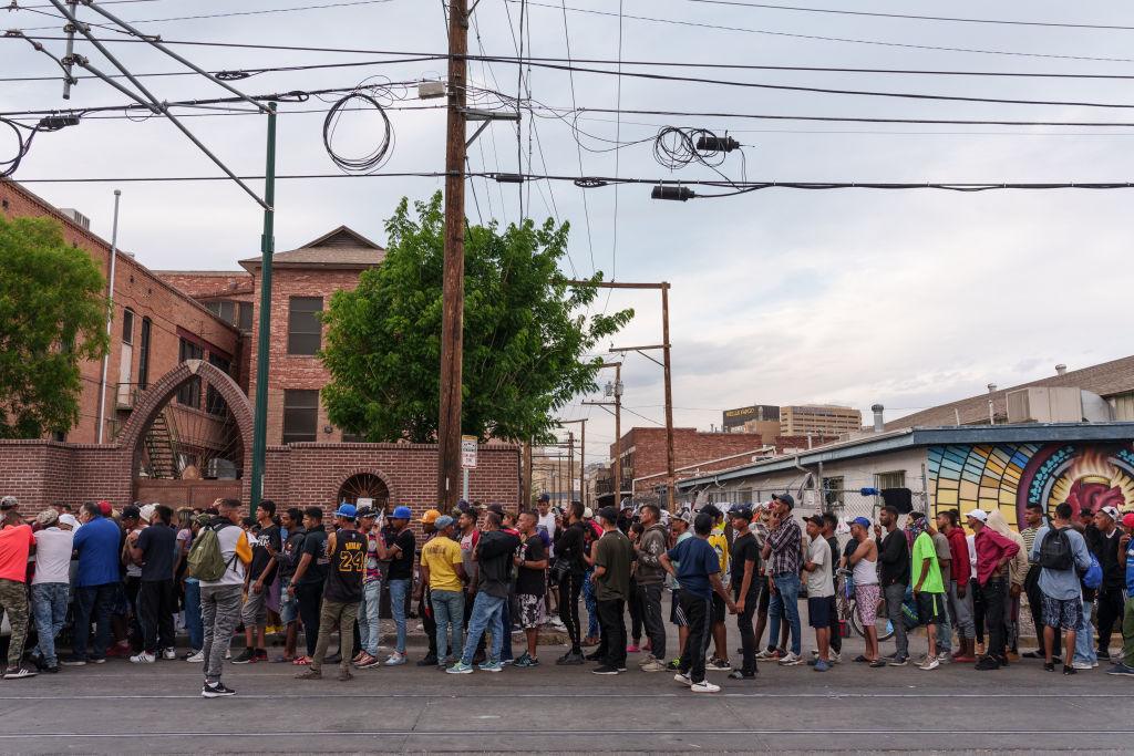 Migrants wait in line for donations outside of Sacred Heart Church before the lifting of Title 42
