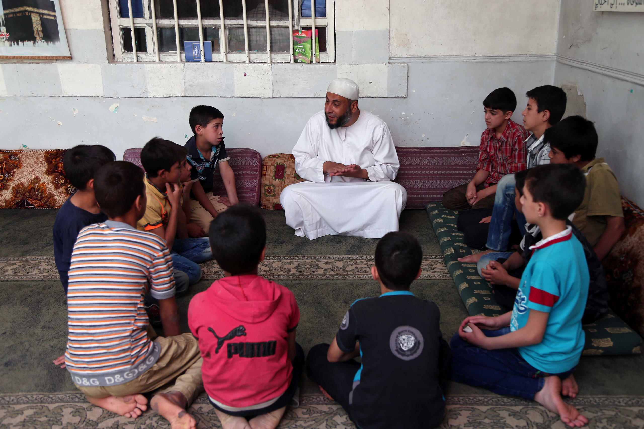 Syrian children attend a lecture at a mosque in Kafr Batna, on the outskirts of the capital Damascus, on the first day of the holy month of Ramadan, June 6, 2016.