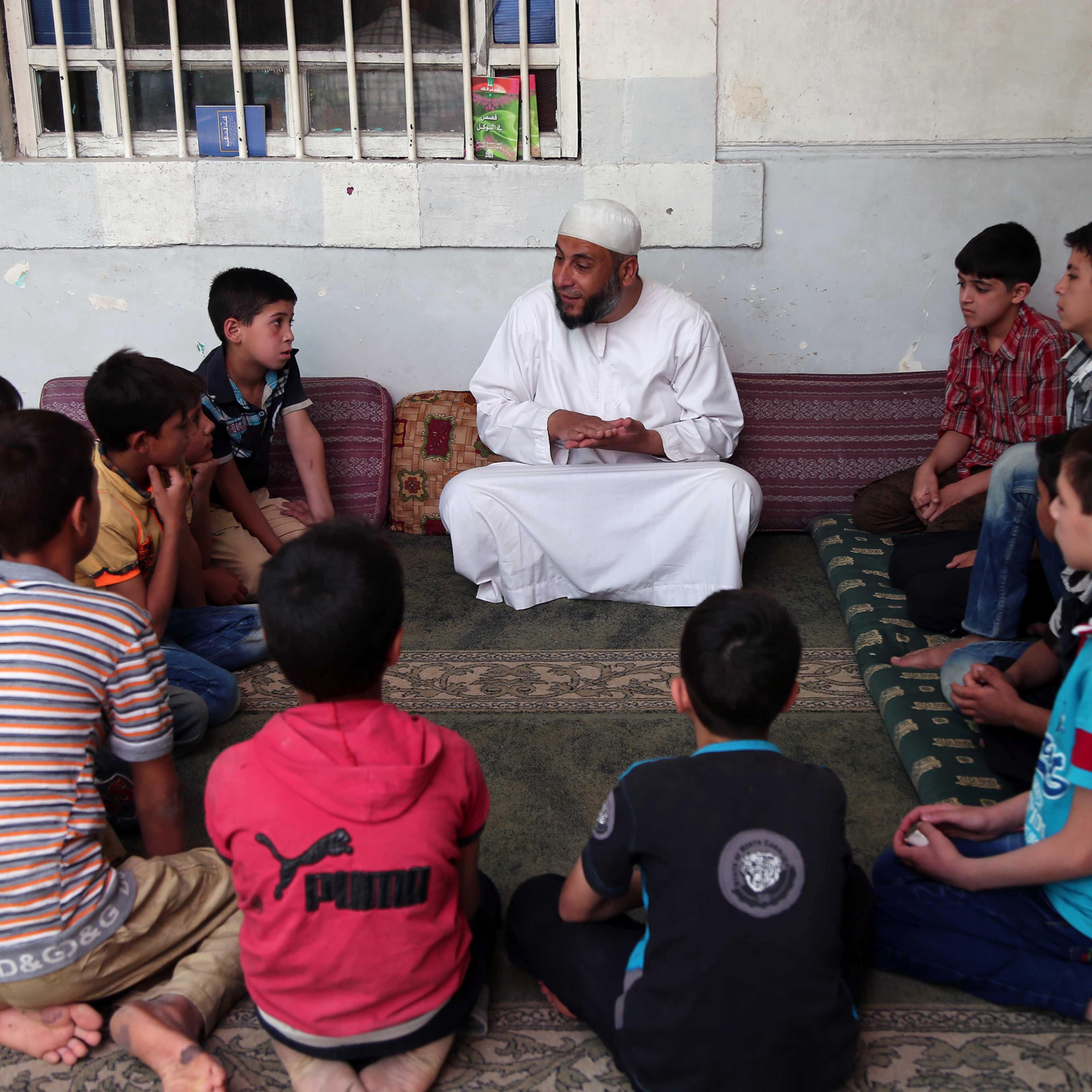 Syrian children attend a lecture at a mosque in Kafr Batna, on the outskirts of the capital Damascus, on the first day of the holy month of Ramadan, June 6, 2016.