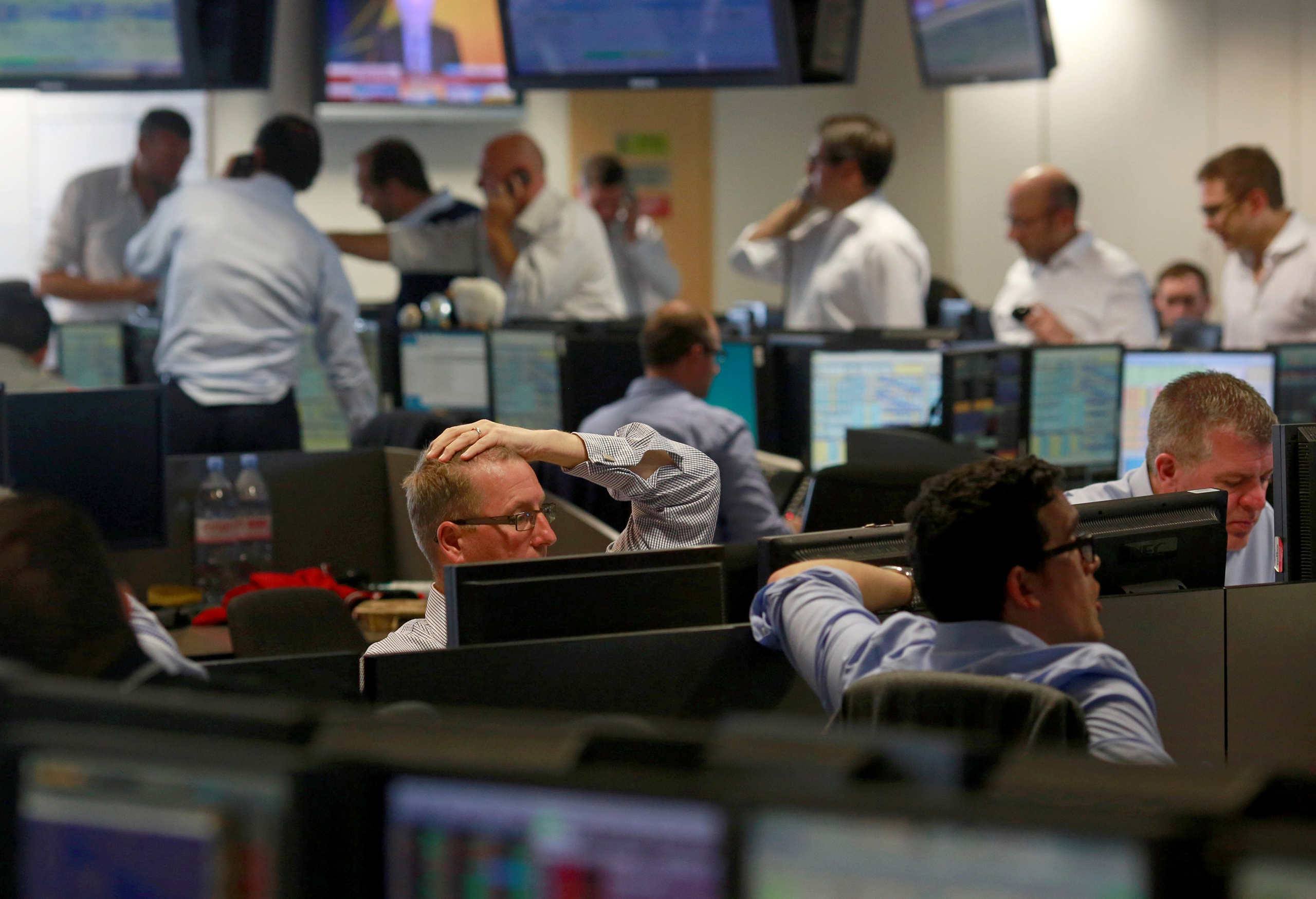 Traders from BGC, a global brokerage company in London's Canary Wharf financial centre react as European stock markets open early after Britain voted to leave the European Union on June 24, 2016.