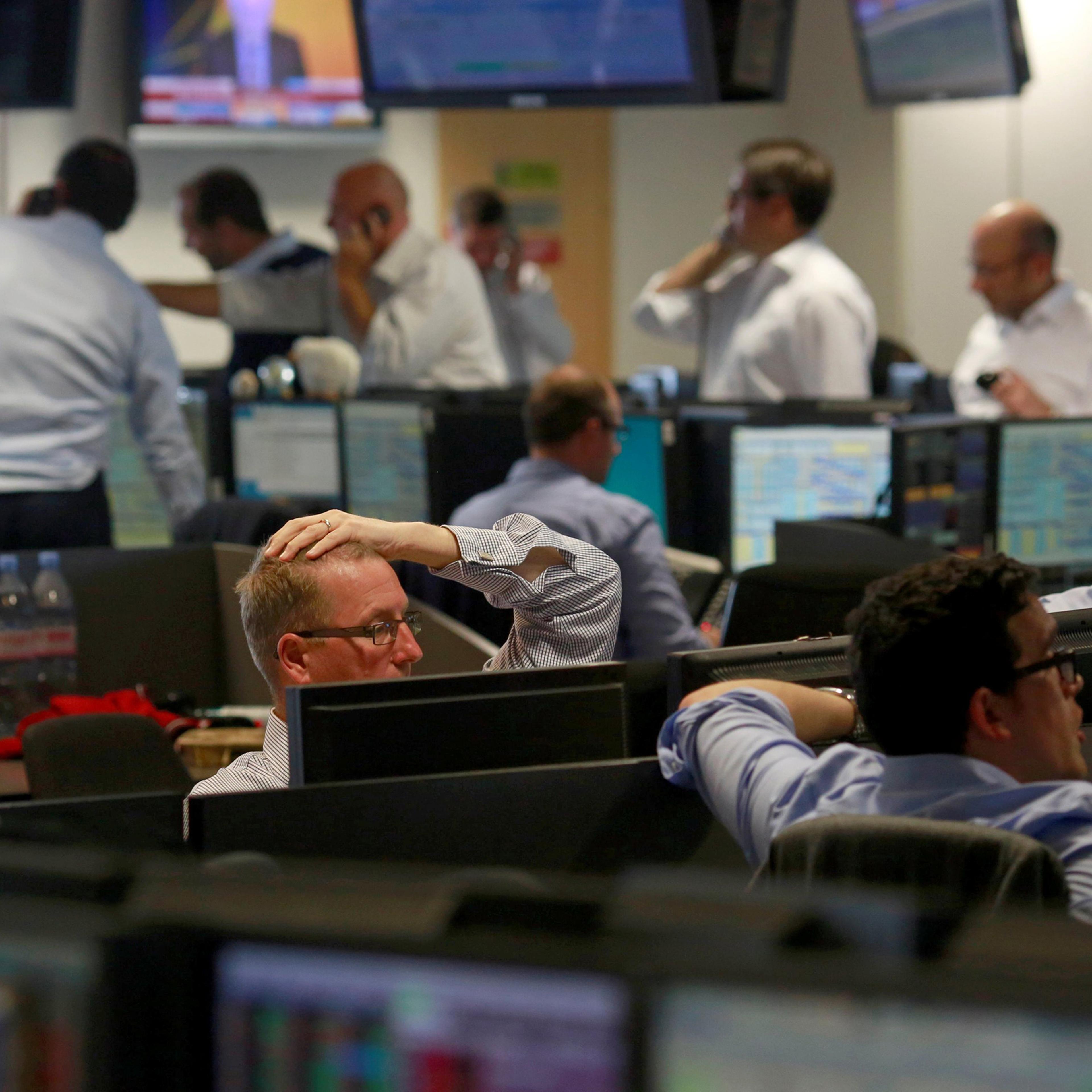 Traders from BGC, a global brokerage company in London's Canary Wharf financial centre react as European stock markets open early after Britain voted to leave the European Union on June 24, 2016.