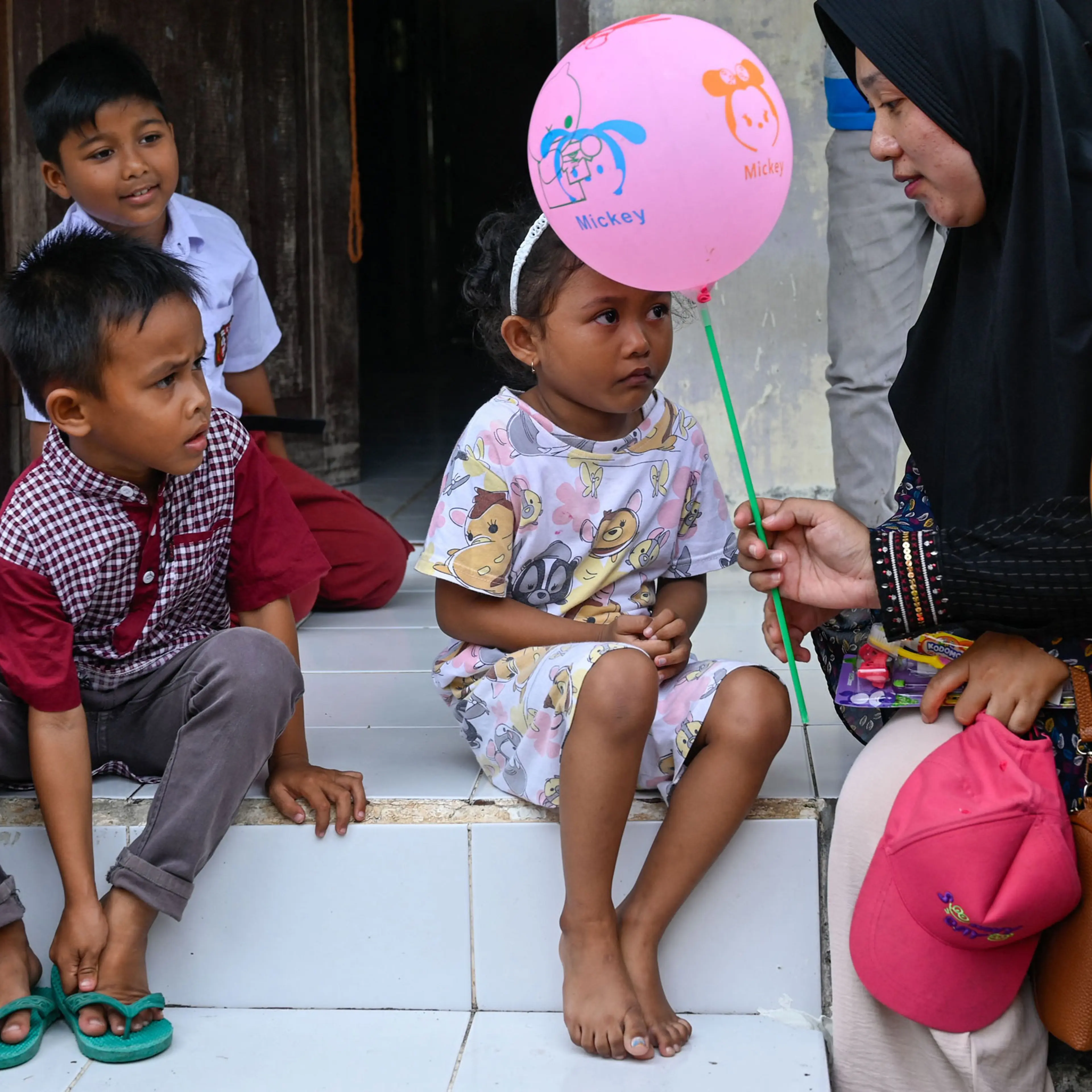 A health worker hands a balloon to a child after she was administered the polio vaccine during a vaccination drive in Pulo Aceh, a remote island in Aceh province, Indonesia, on Dec. 6, 2022.
