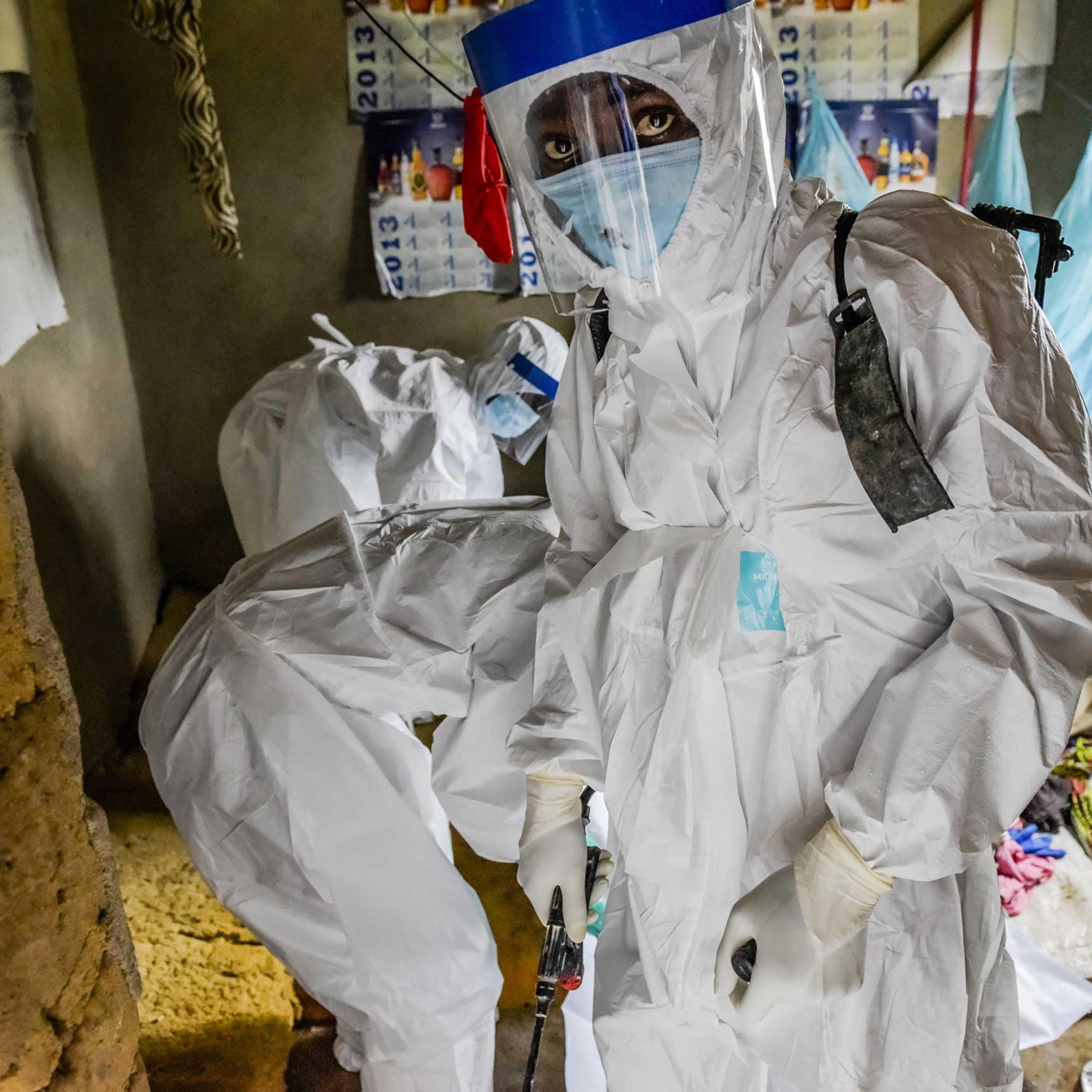 A burial team extracts the body of Isatu Sesay, 16, an Ebola victim, from her home in Kissi Town, Sierra Leone.