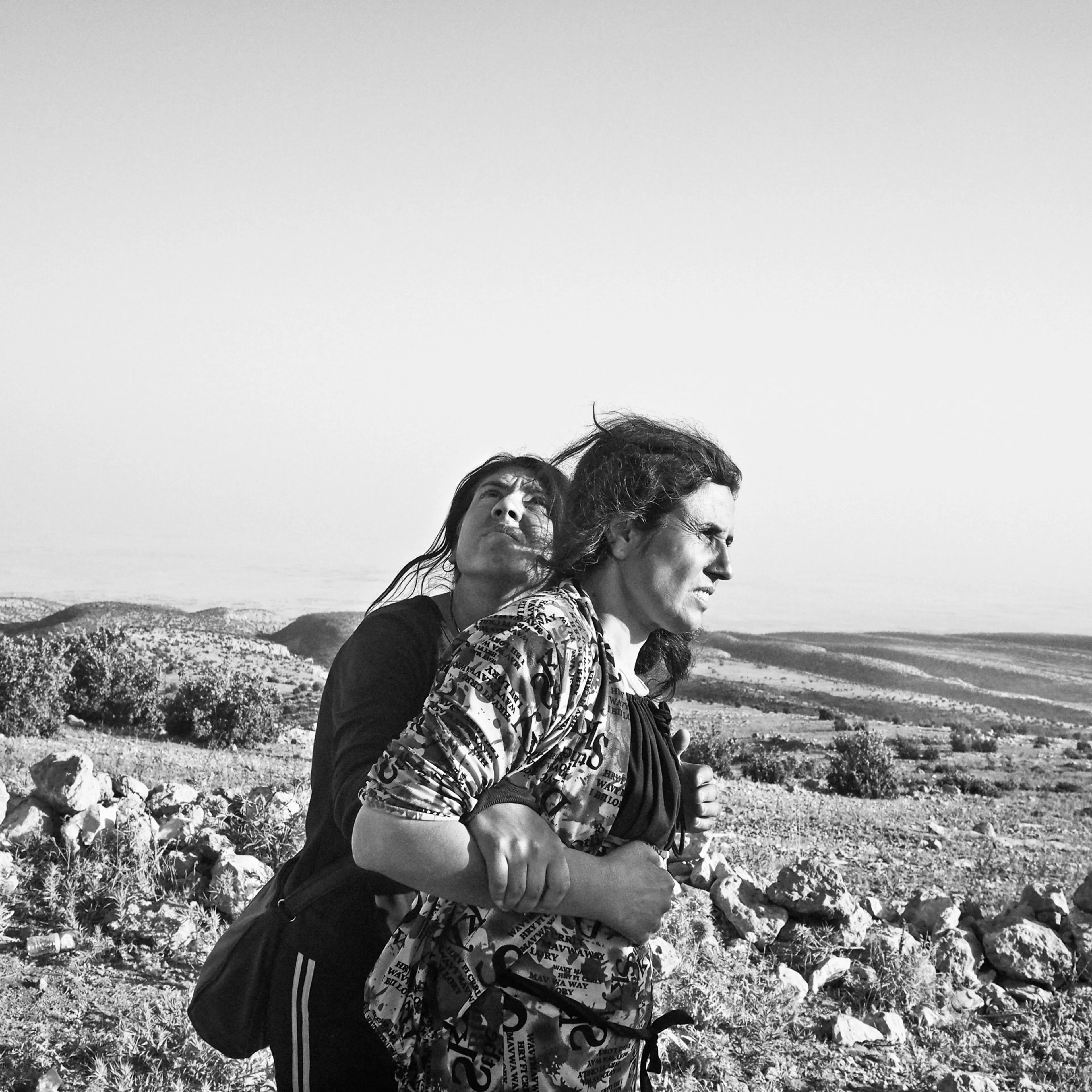 Yezidi women stranded in the Sinjar Mountains wait for the arrival of a rescue helicopter. Iraq. Aug. 12, 2014.