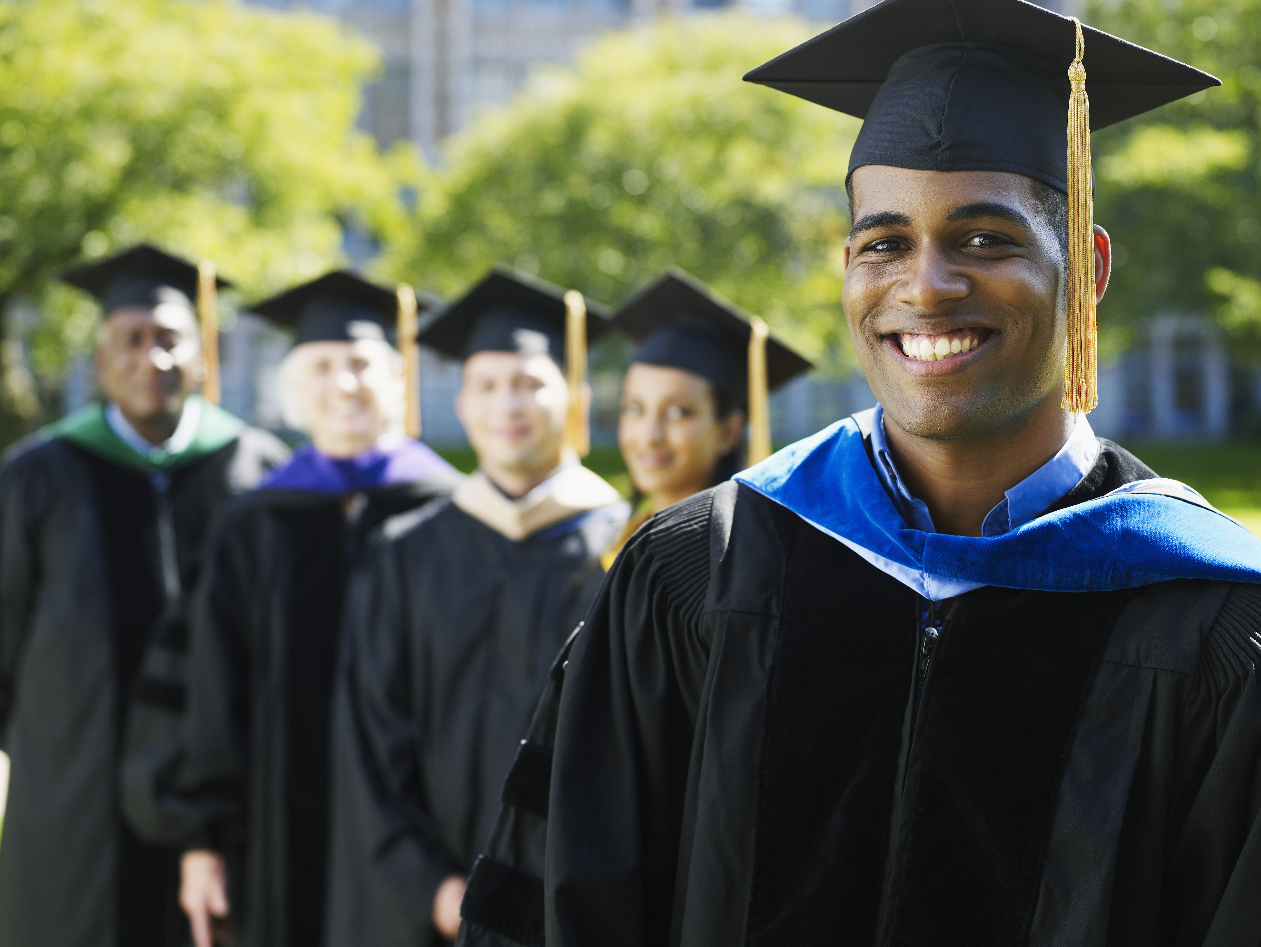 Portrait of university graduate with others in background (focus on foreground)