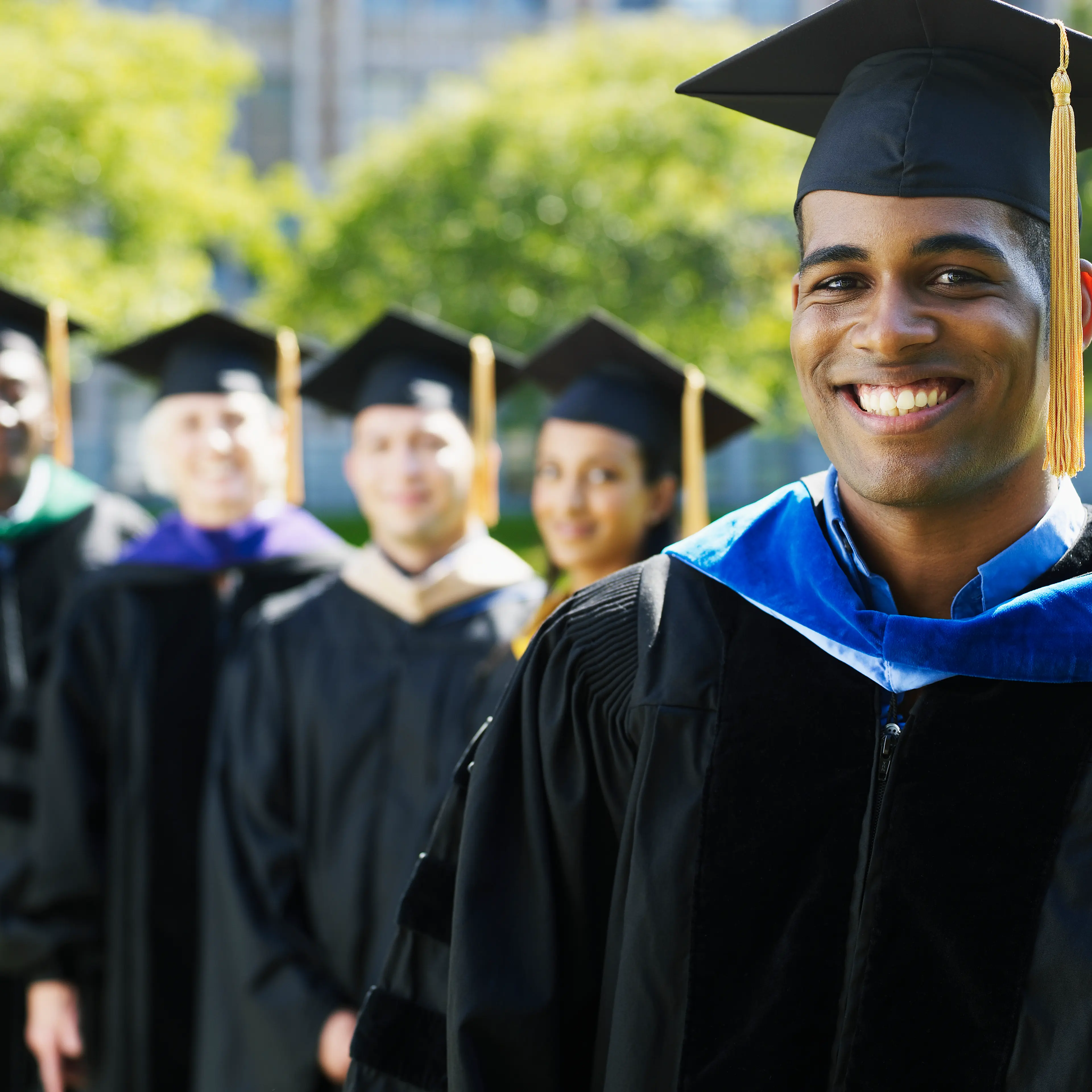 Portrait of university graduate with others in background (focus on foreground)