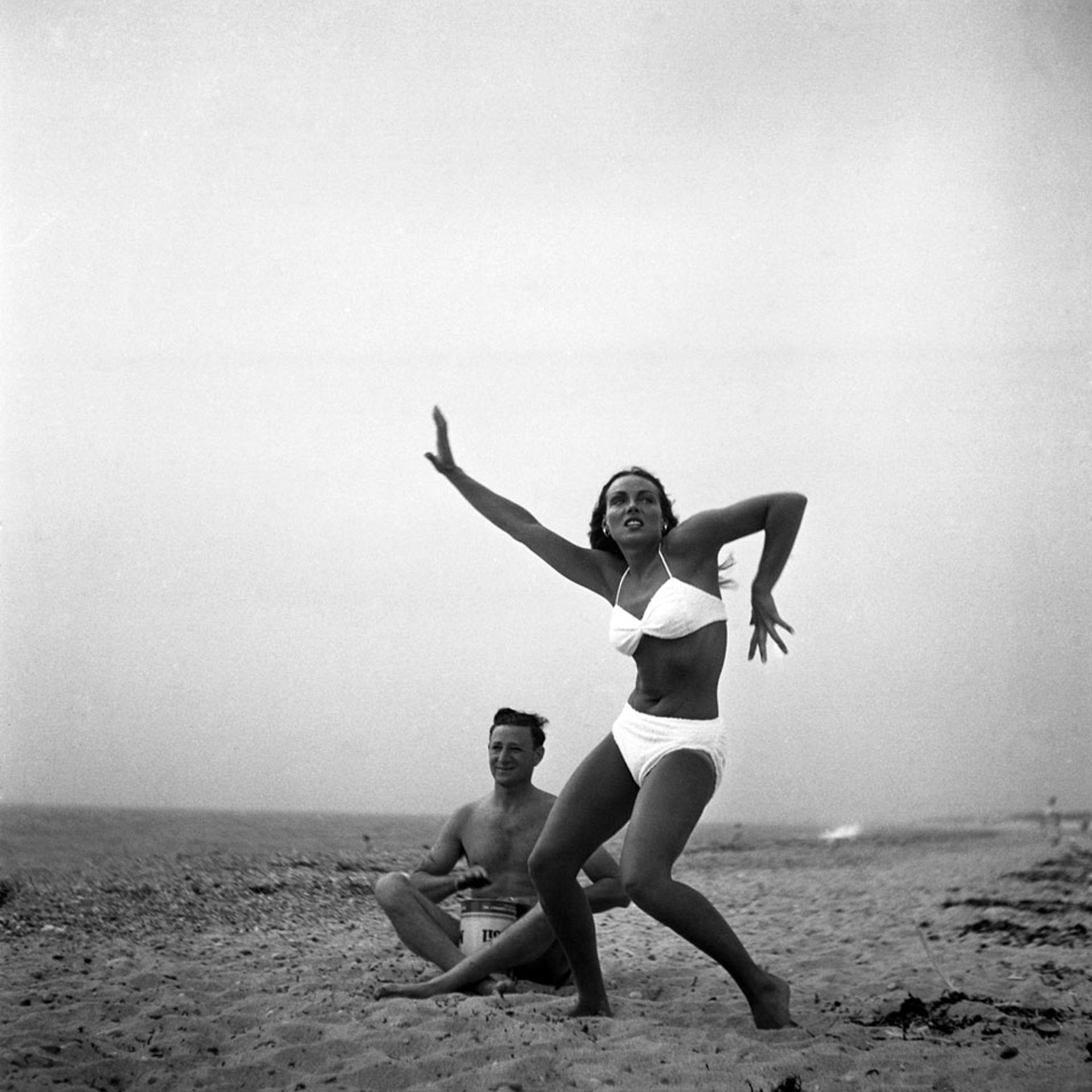 Caption from LIFE: "Ann Converse, member of old Boston family who works as Cape Cod waitress, expresses Activationist joy while friend beats oilcan tom-tom."