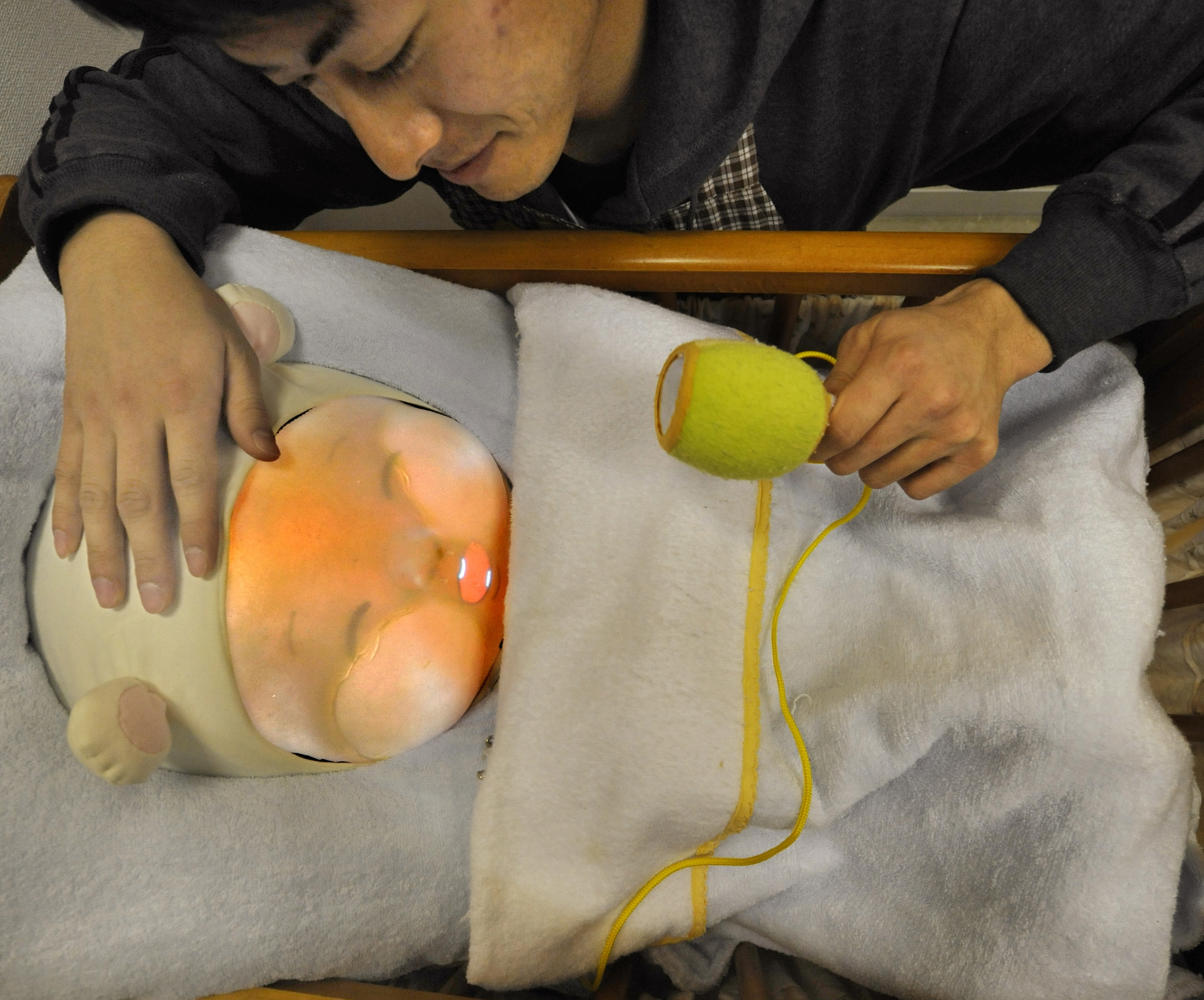 Tamura An engineering student soothes a baby robot during a presentations at a lboratory in Tsukuba University, Ibaraki Prefecture on February 12, 2010.