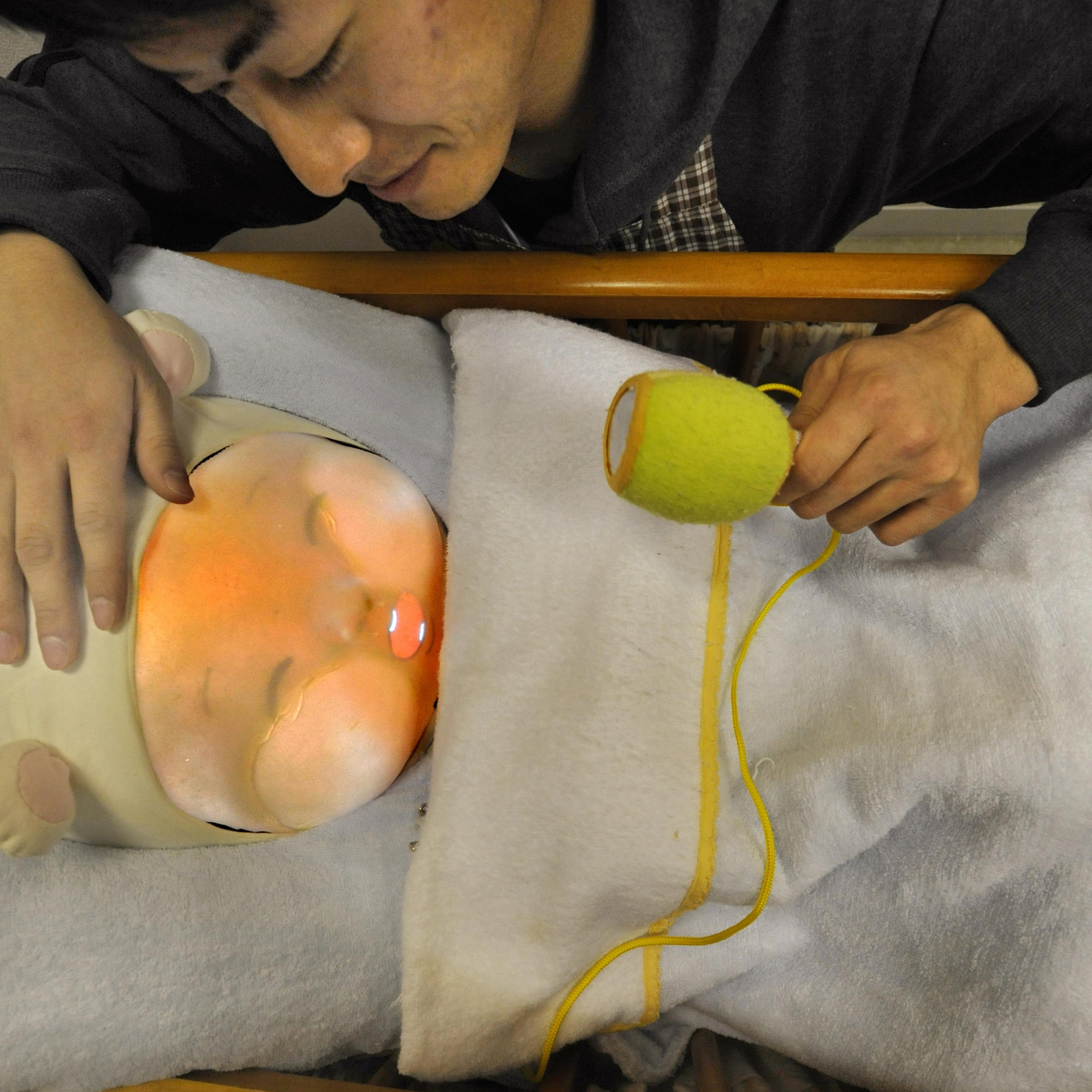 Tamura An engineering student soothes a baby robot during a presentations at a lboratory in Tsukuba University, Ibaraki Prefecture on February 12, 2010.