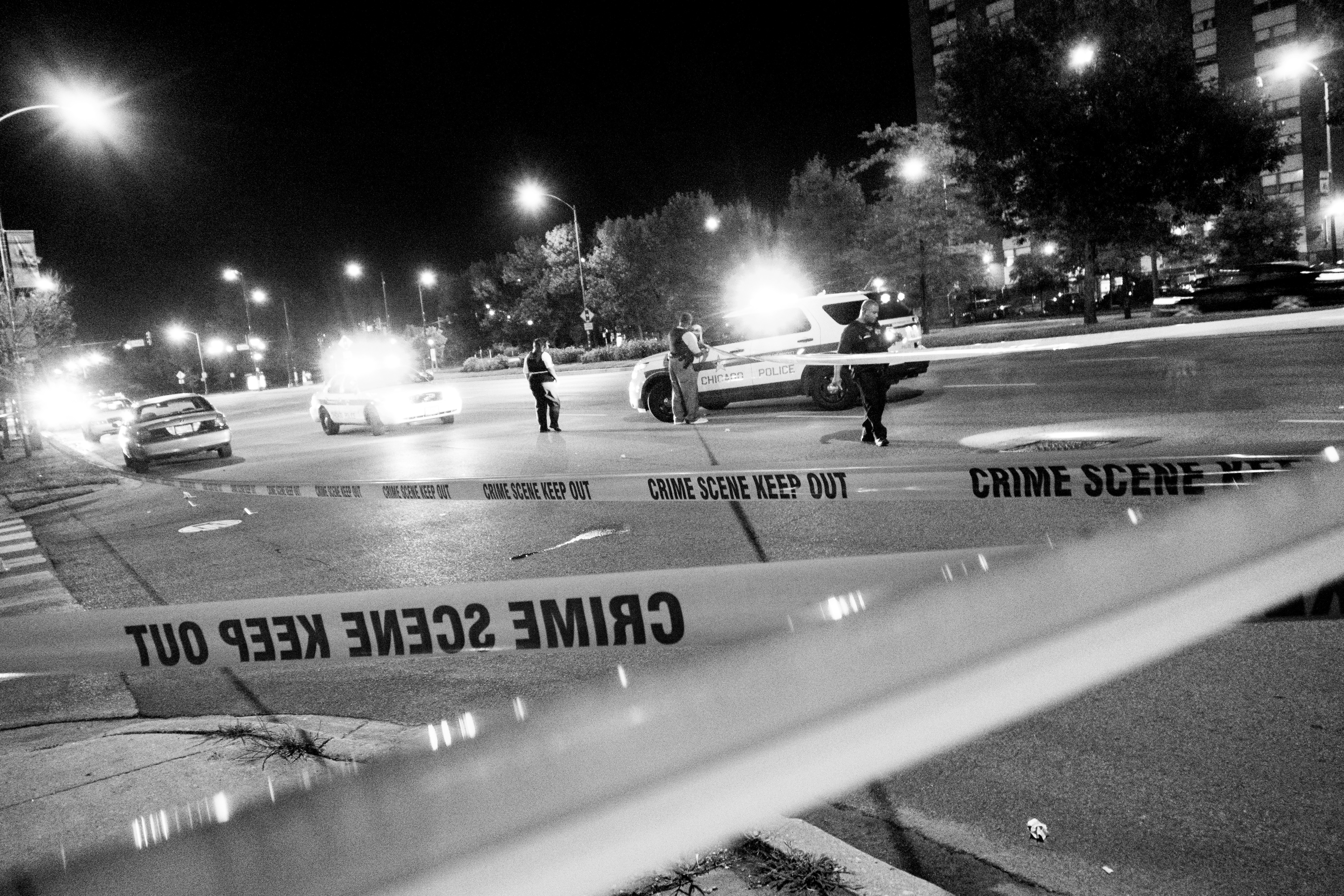 CHICAGO, IL. USA. September 2014Chicago police officers look for evidence after four people were hit as they stood in the parking lot of a Pizza Hut at 67th Street and Stony Island Avenue around 10:40 p.m. Monday Aug 25. A 16-year-old girl was shot in th