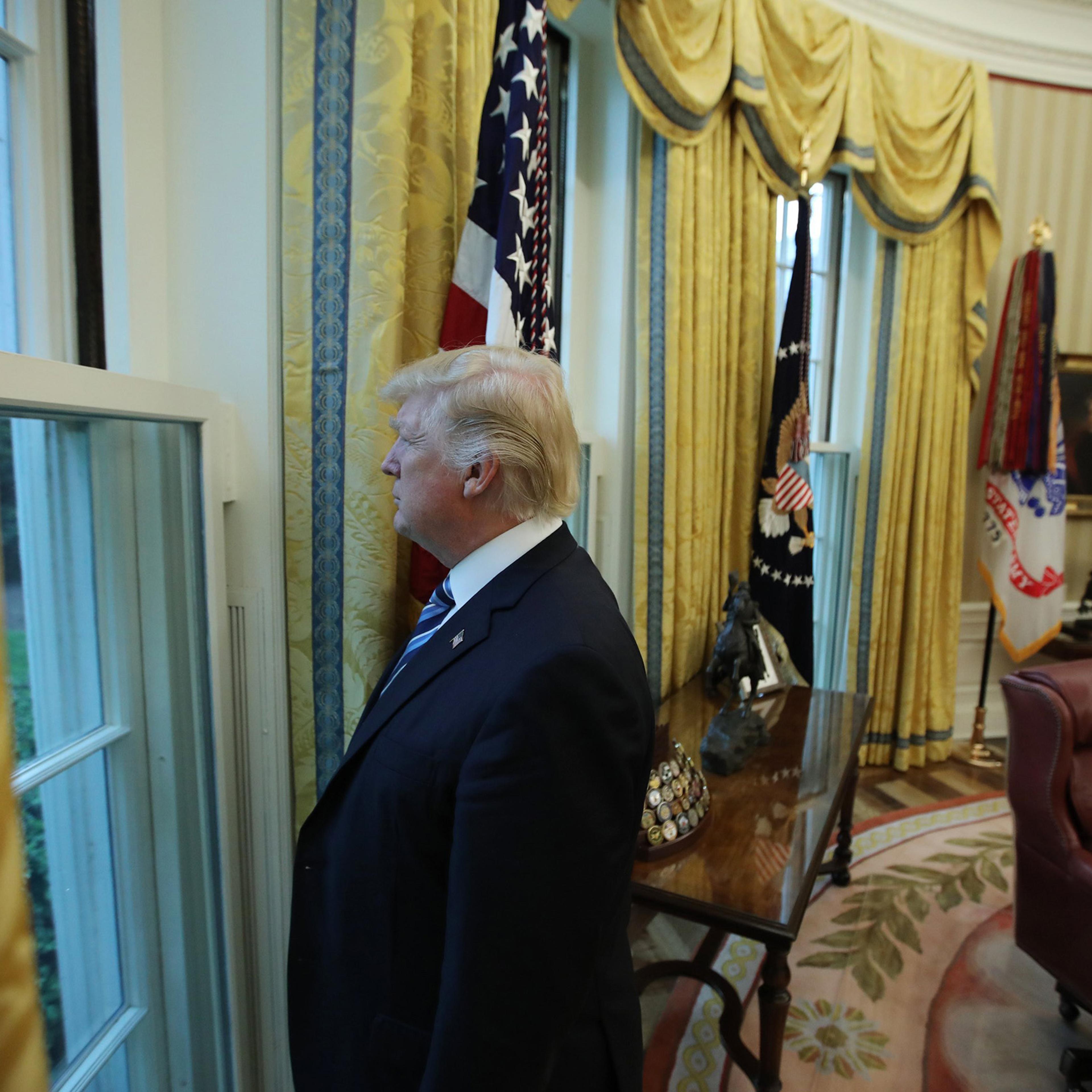 U.S. President Donald Trump looks out window of the Oval Office following an interview with Reuters at the White House in Washington