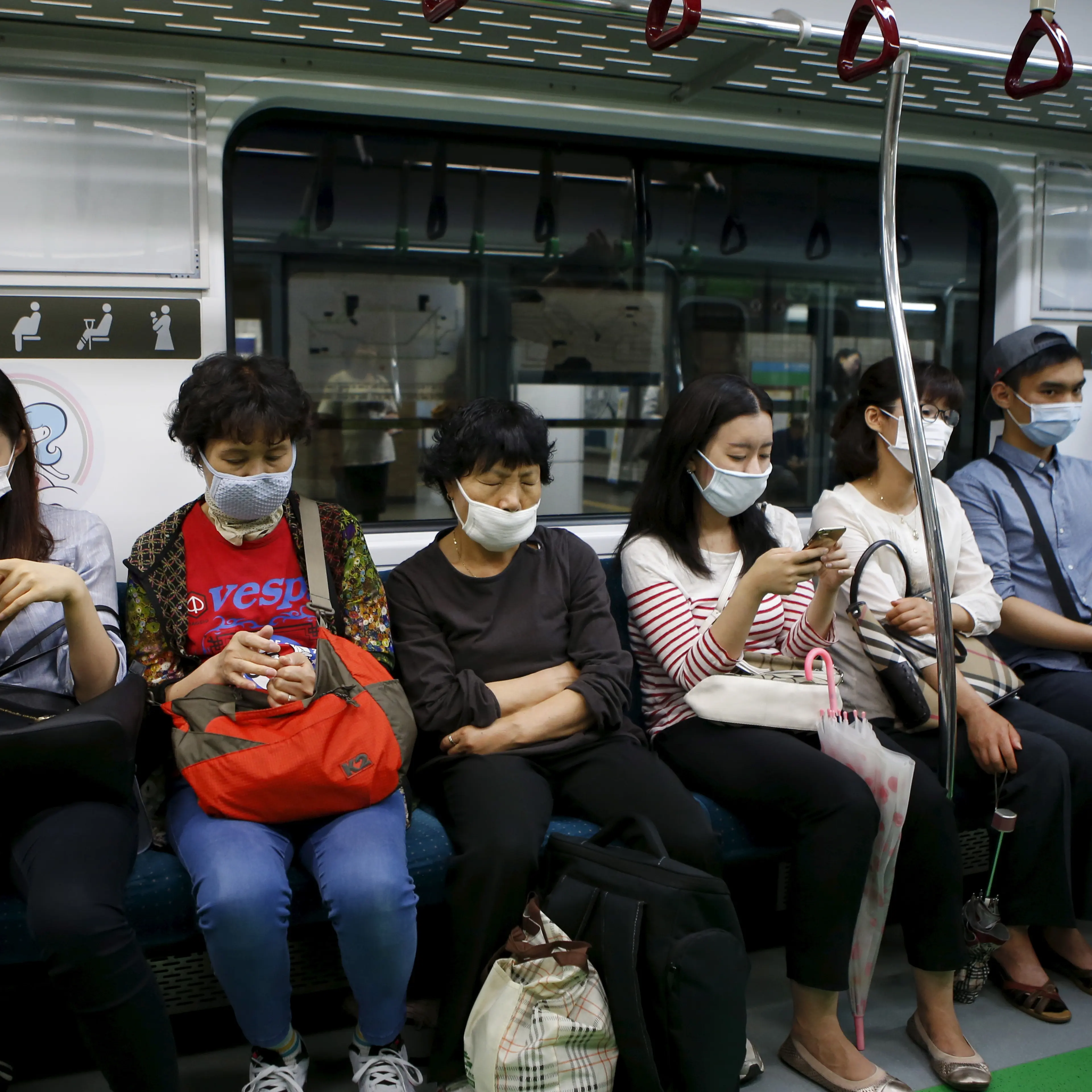 Passengers wearing masks to prevent contracting Middle East Respiratory Syndrome (MERS) sit inside a train in Seoul
