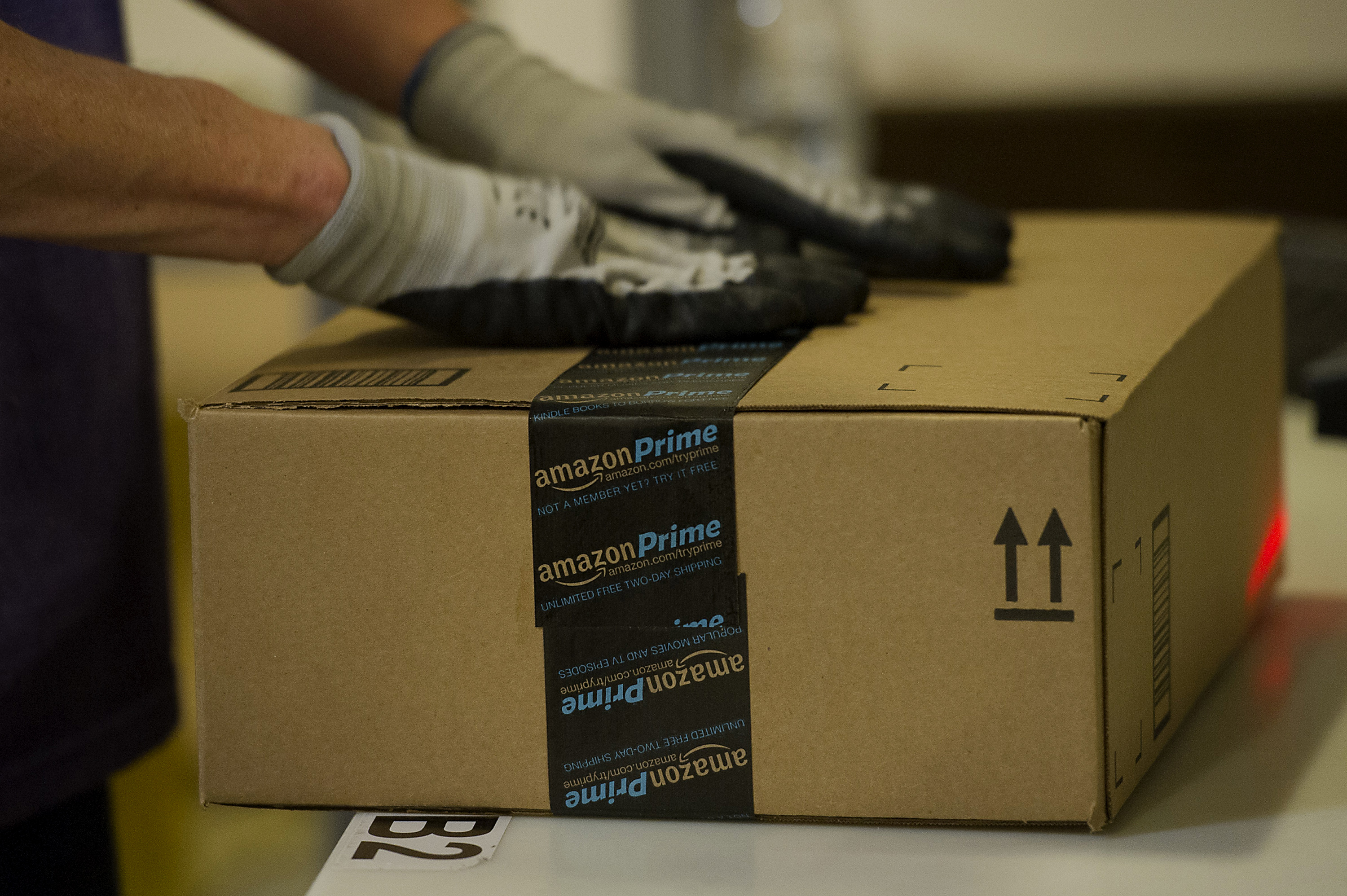 An employee seals a box at the Amazon.com Inc. fulfillment center in Phoenix, Arizona on Dec. 2, 2013.