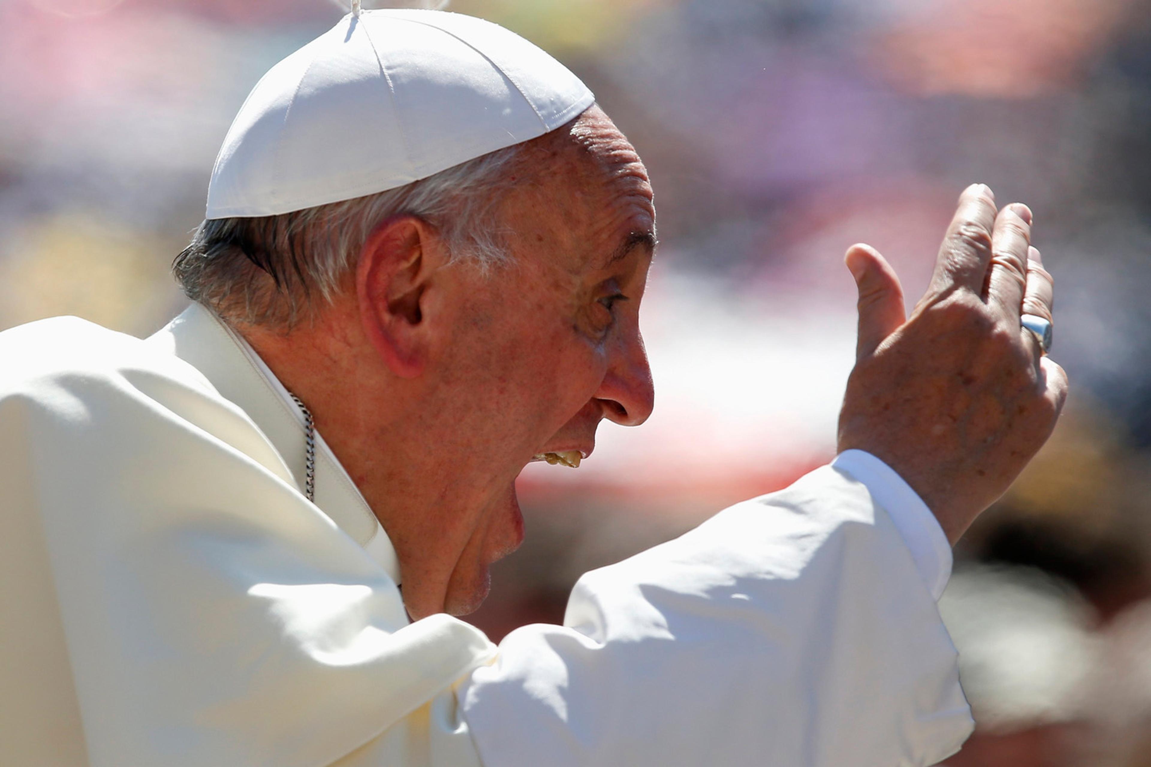 Pope Francis waves as he arrives to lead the weekly audience in Saint Peter's Square at the Vatican