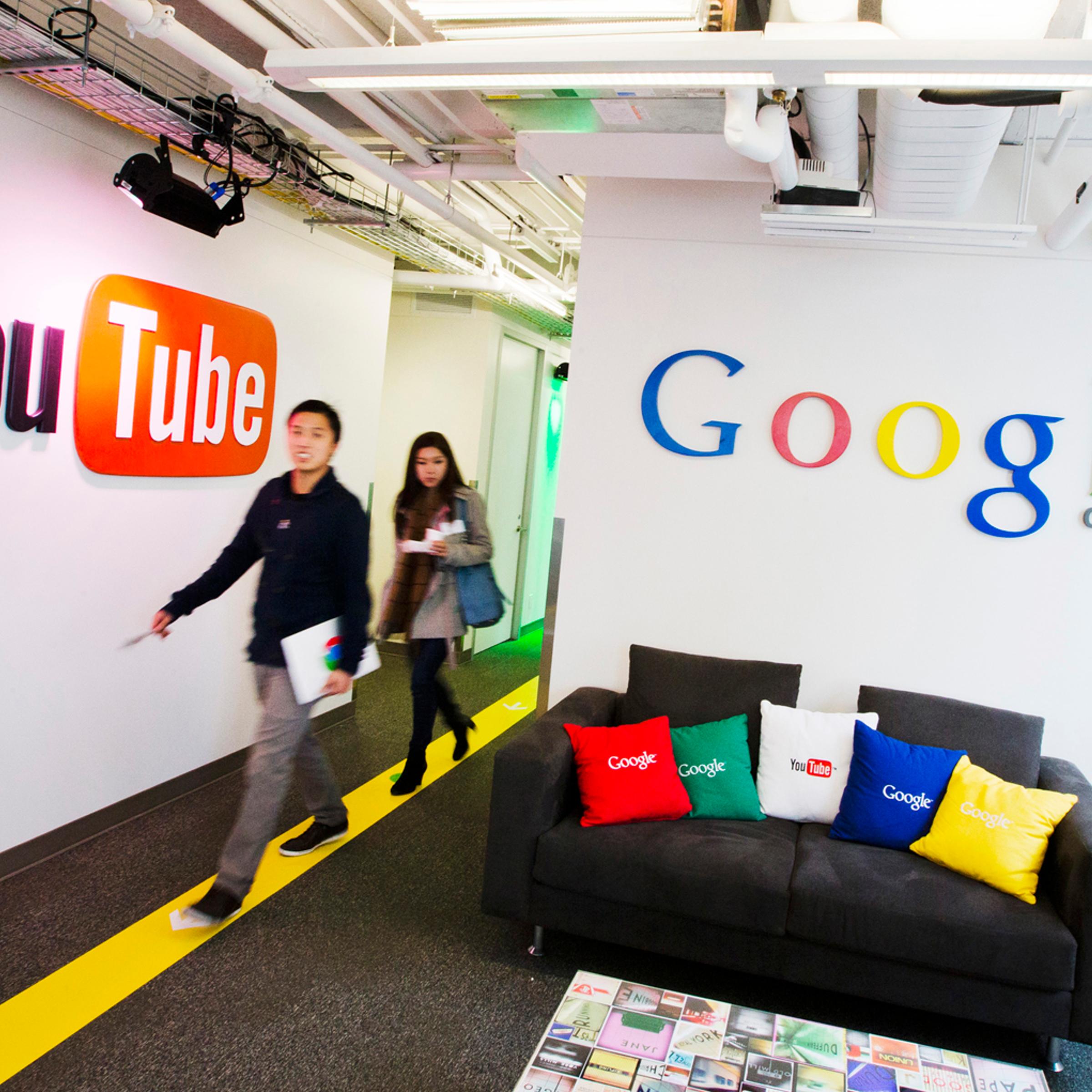 People walk by a YouTube sign at the new Google office in Toronto, Nov. 13, 2012.