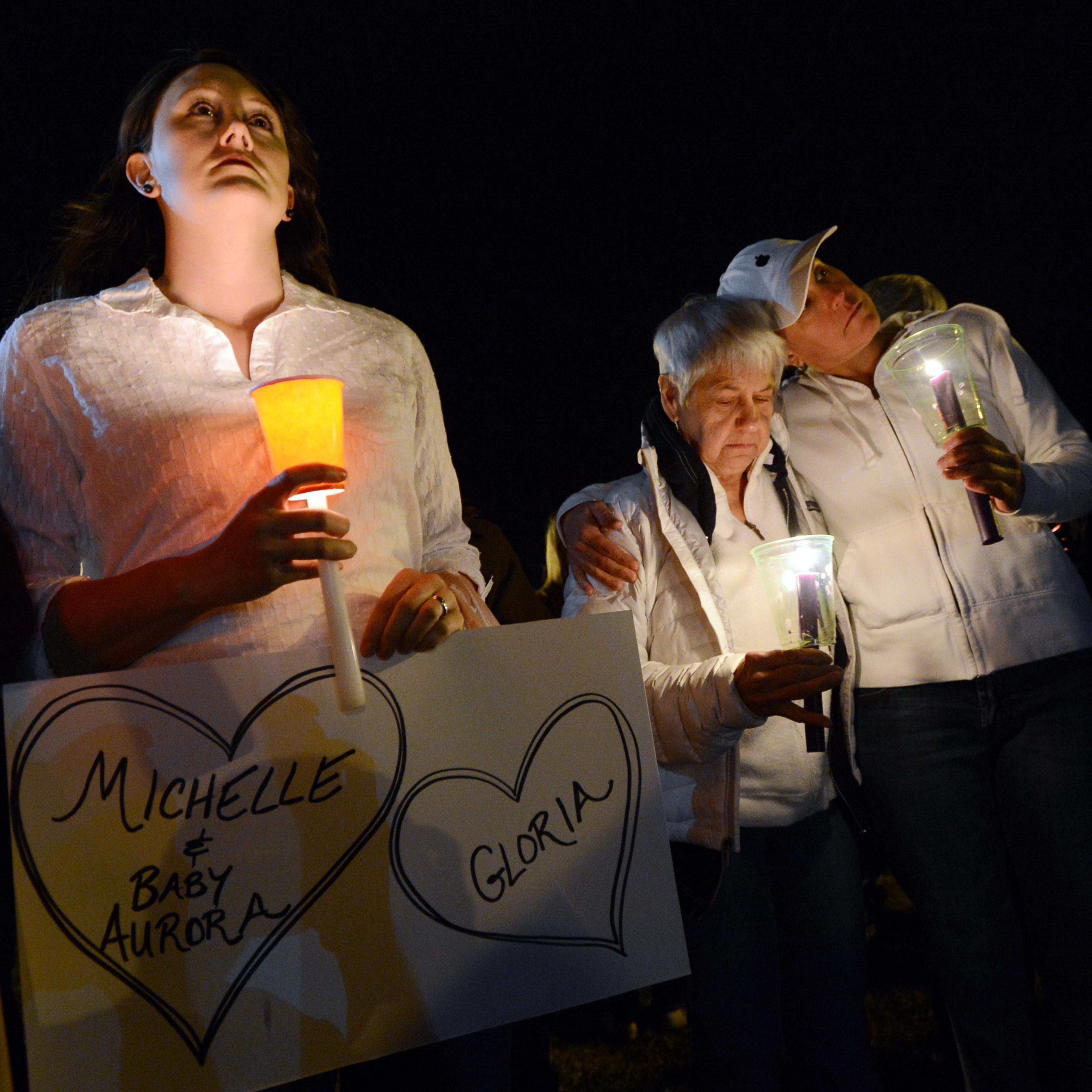 Cheryl Swanson, left, Elaine Derstine, and her daughter, Michelle Smith, are part of a moment of silence during the vigil.