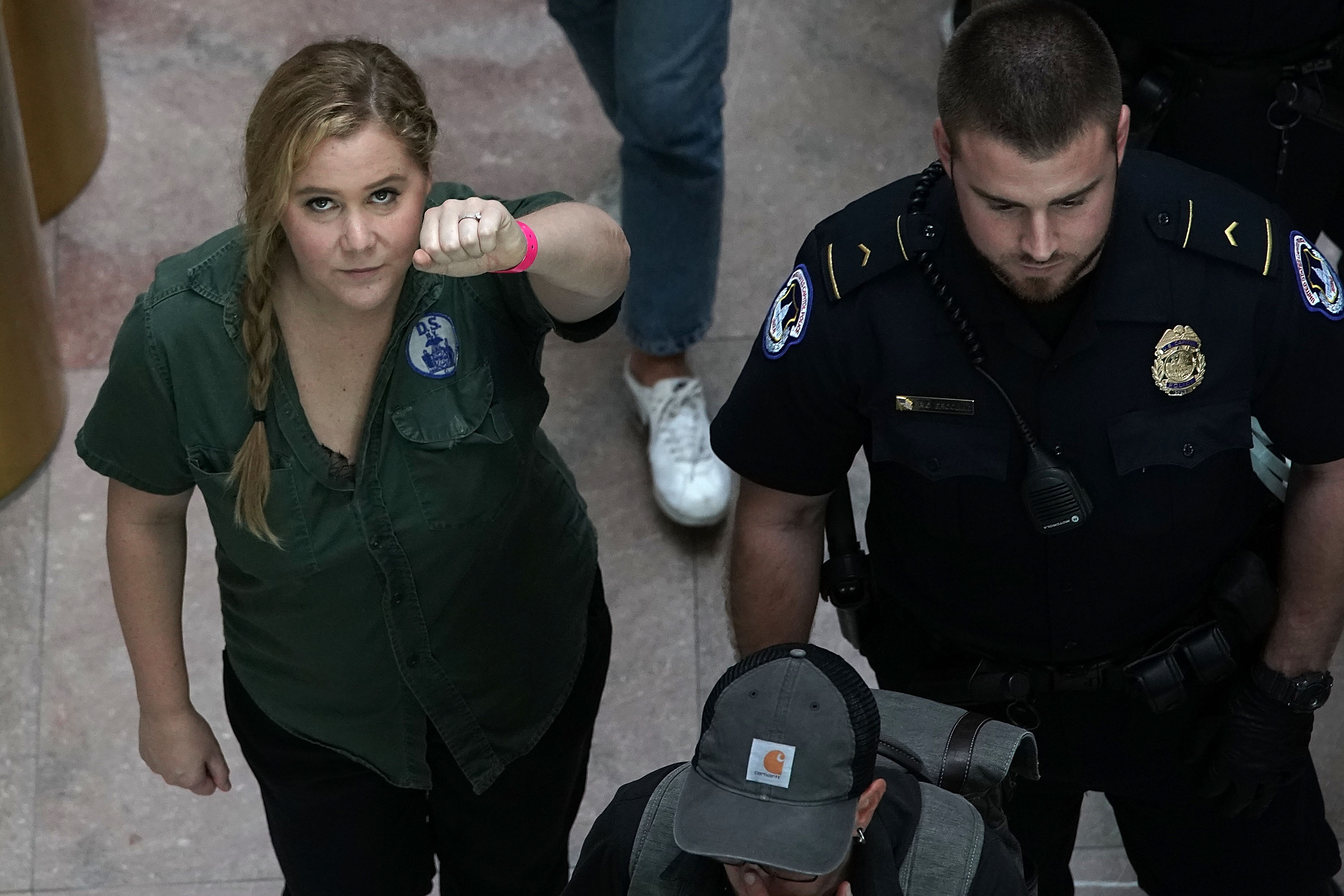 WASHINGTON, DC - OCTOBER 04: Comedian Amy Schumer (L) is led away after she was arrested during a protest against the confirmation of Supreme Court nominee Judge Brett Kavanaugh October 4, 2018 at the Hart Senate Office Building on Capitol Hill in Washin