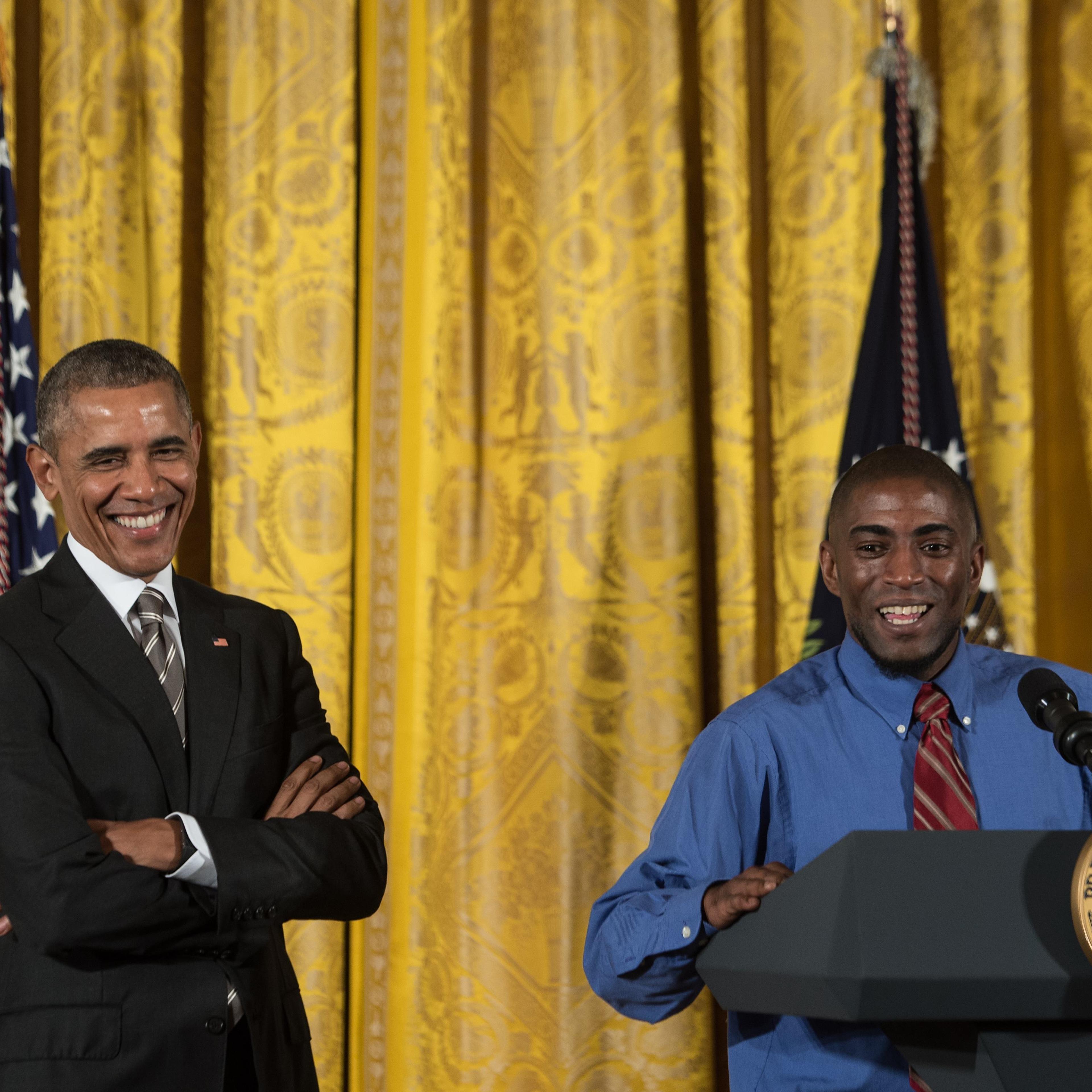 US President Barack Obama (L) smiles as he is introduced by fast food worker Terrence Wise at the Summit on Worker Voice at the White House in Washington, DC, on Oct. 7, 2015.