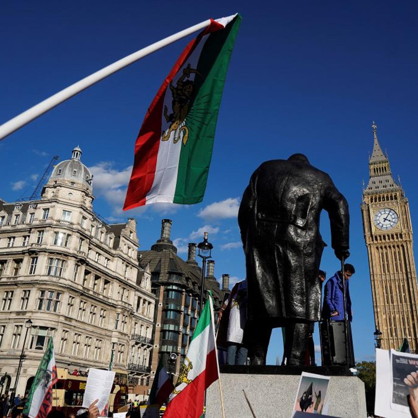 People wave flags and hold placards during a protest following the death of Mahsa Amini who died in custody of Iran's morality police, in London on Oct 8, 2022.
