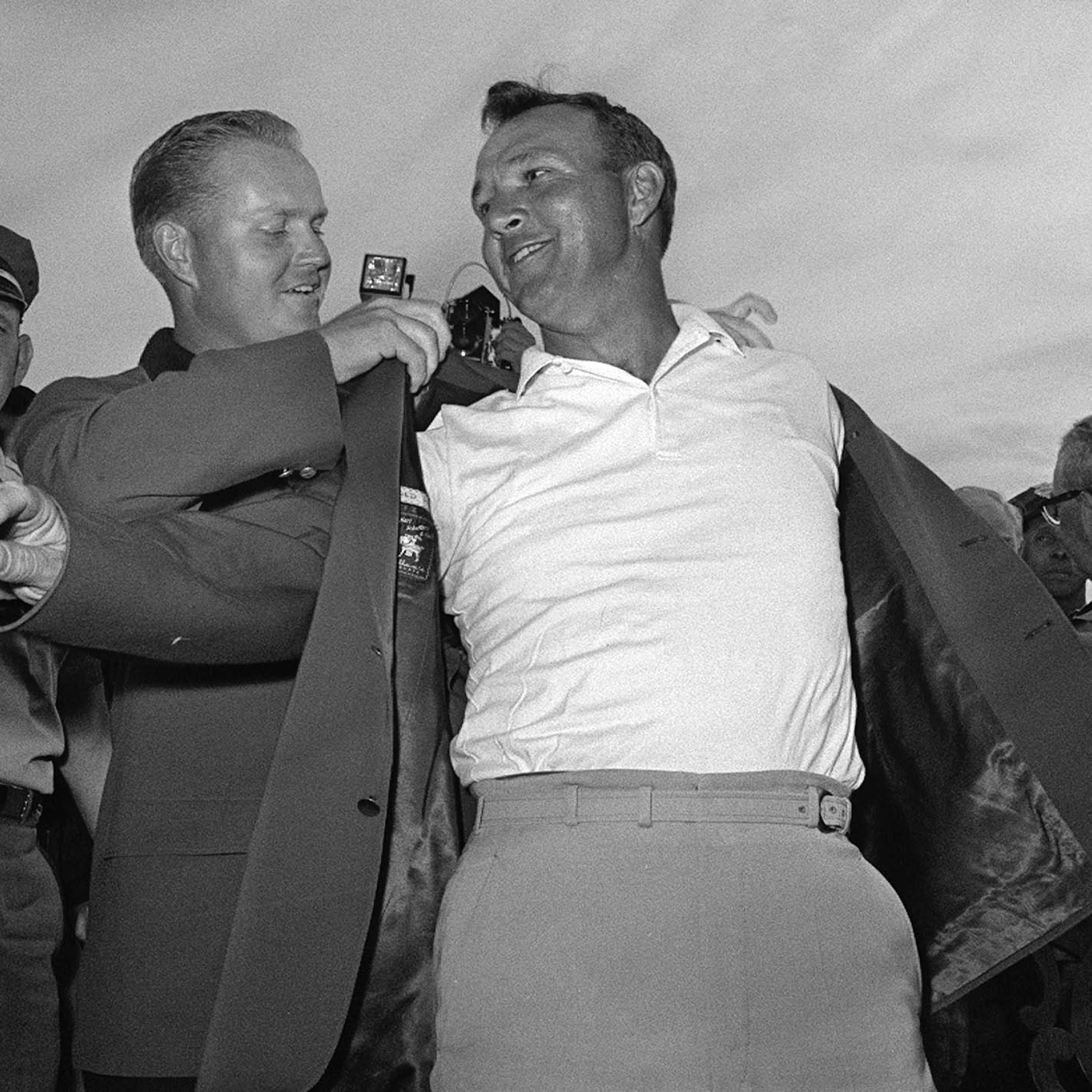 Arnold Palmer, right, slips into his green jacket with help from Jack Nicklaus after winning the Masters golf championship, in Augusta, Ga, April 12, 1964.