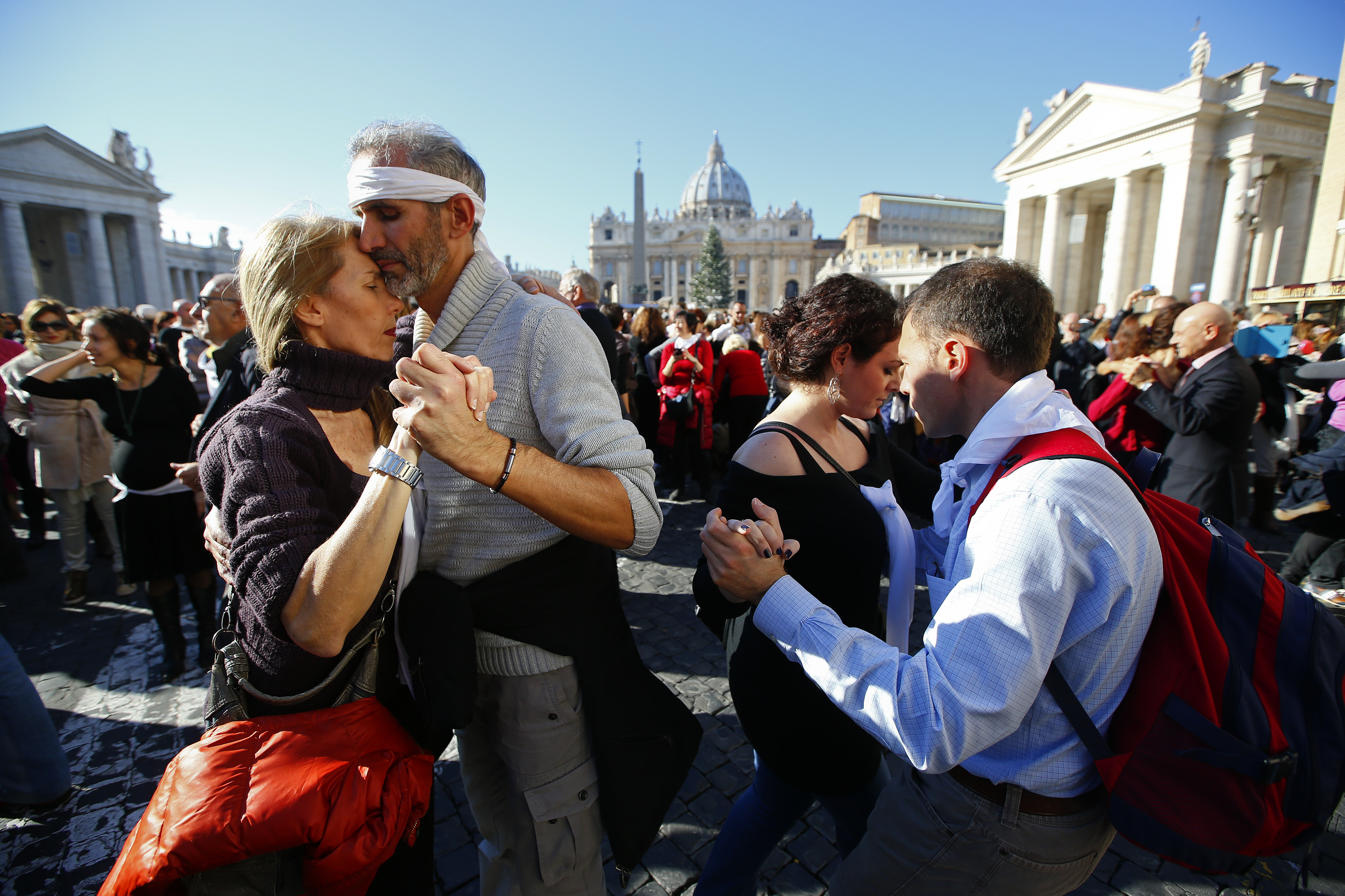 Couples dance a tango in front of Saint Peter's basilica at the Vatican