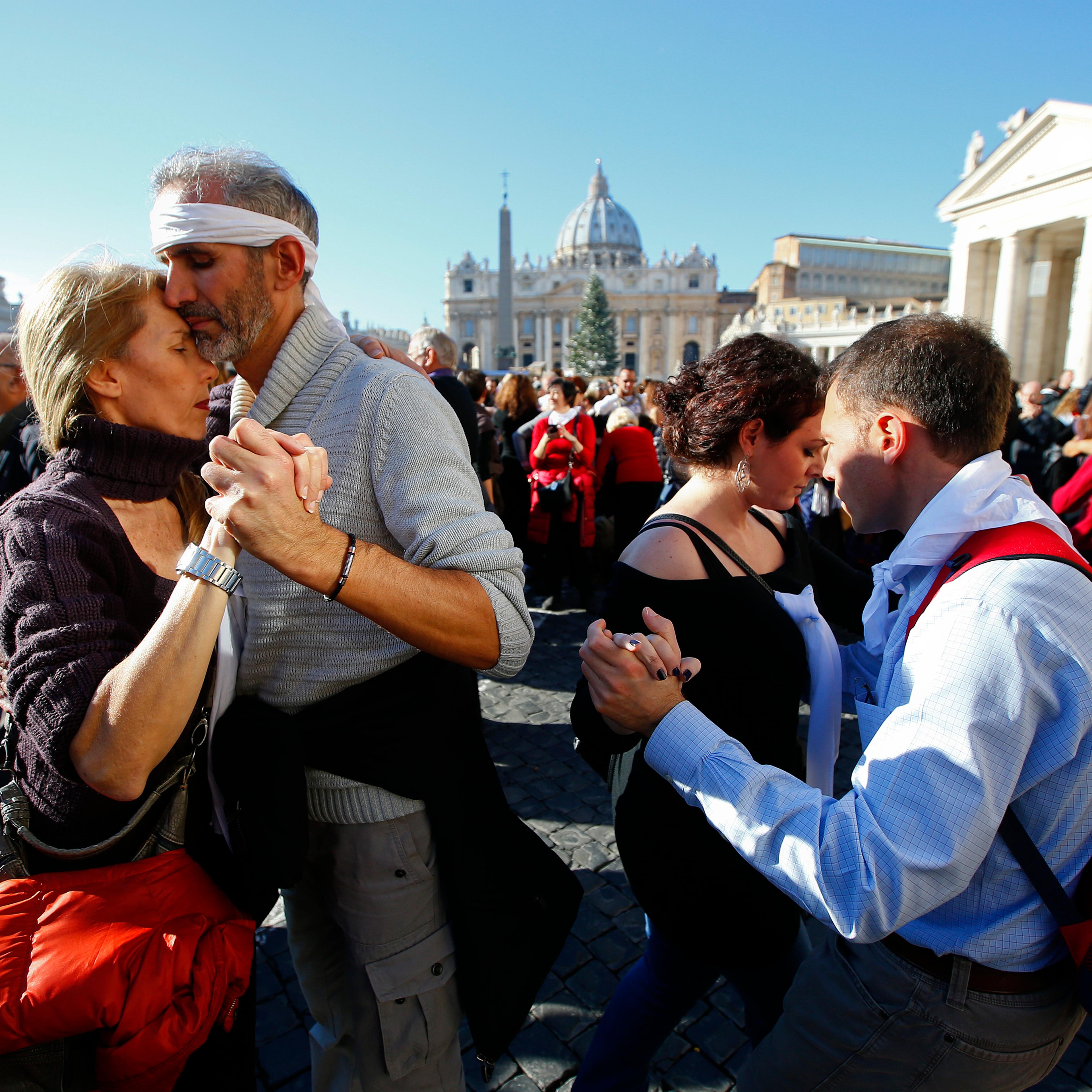 Couples dance a tango in front of Saint Peter's basilica at the Vatican