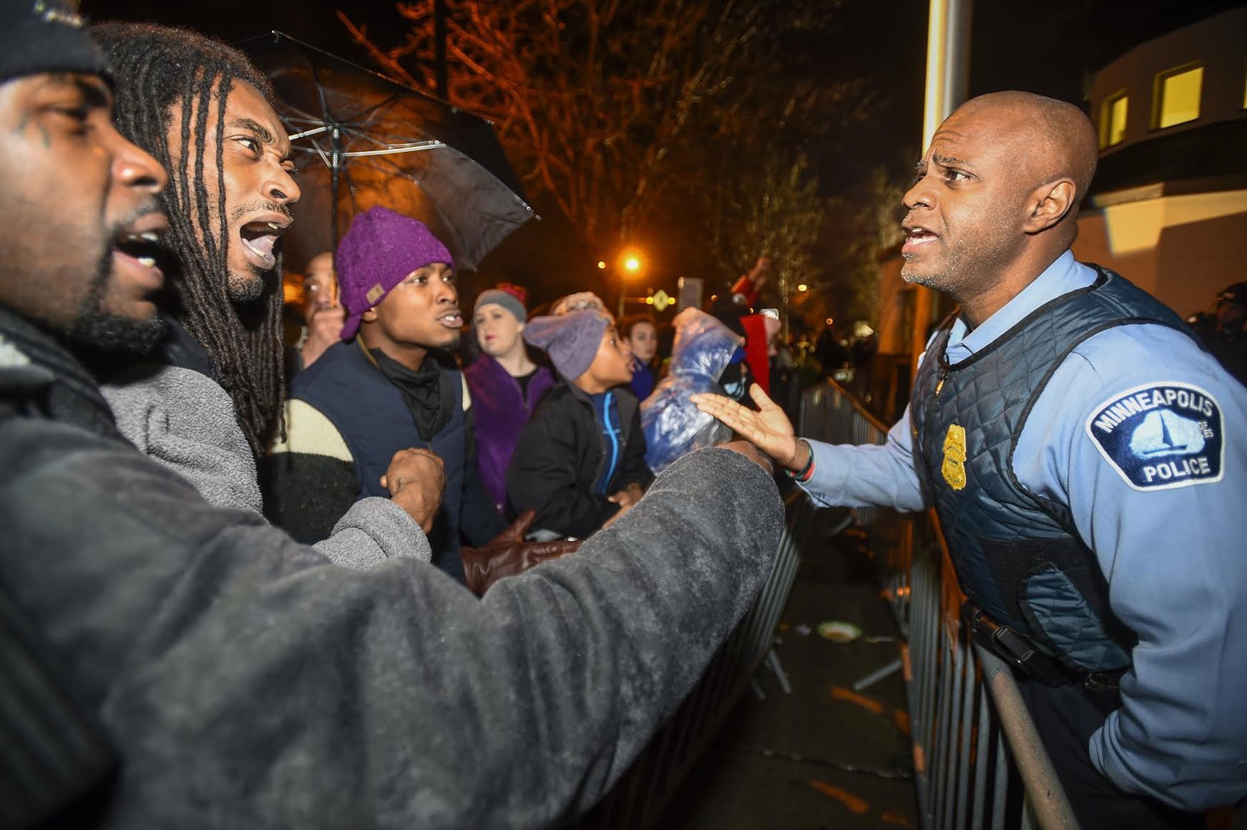 A police officer talks with demonstrators in front of a north Minneapolis police precinct during a protest in response of Sunday's shooting death of Jamar Clark by police officers in Minneapolis on Nov. 18, 2015.