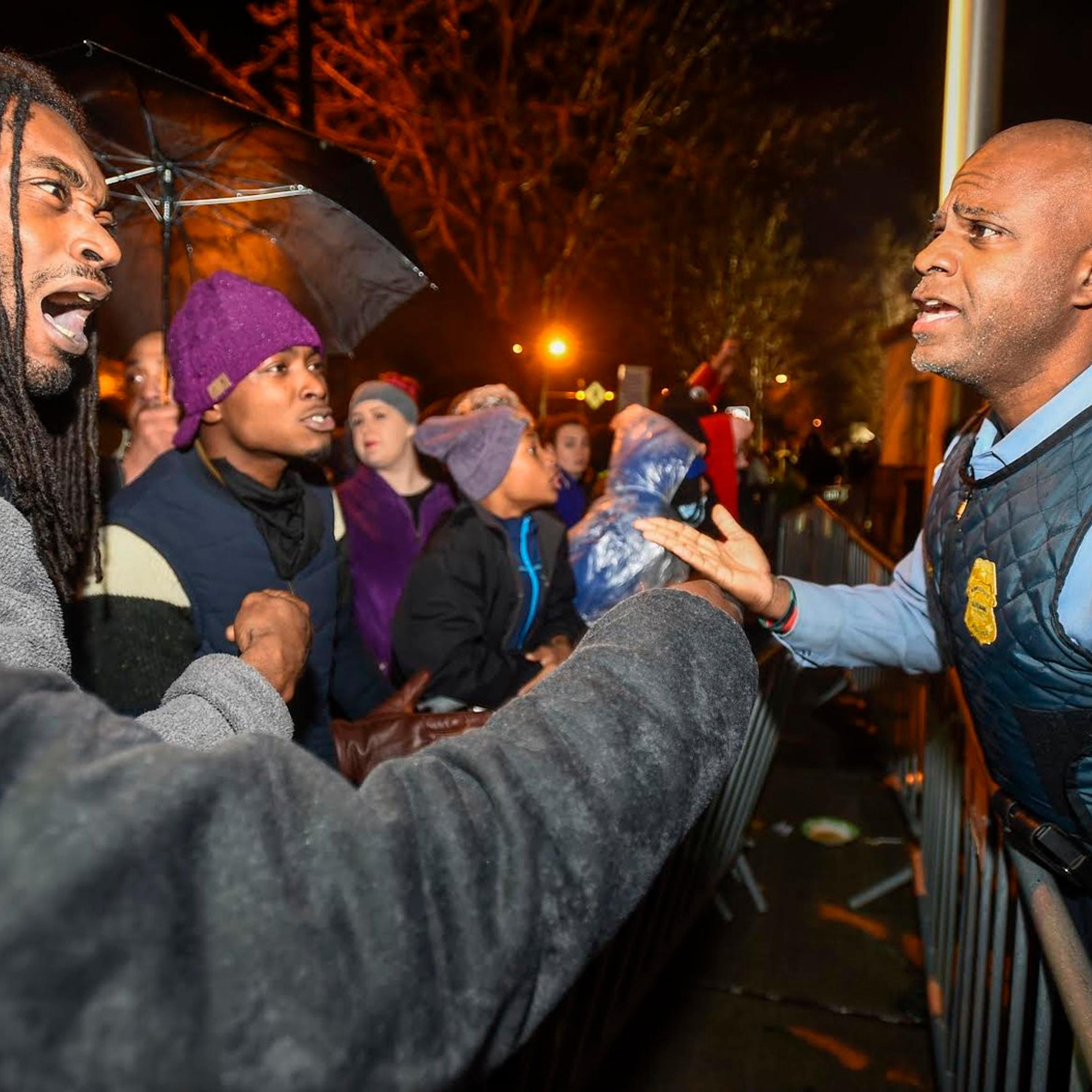 A police officer talks with demonstrators in front of a north Minneapolis police precinct during a protest in response of Sunday's shooting death of Jamar Clark by police officers in Minneapolis on Nov. 18, 2015.