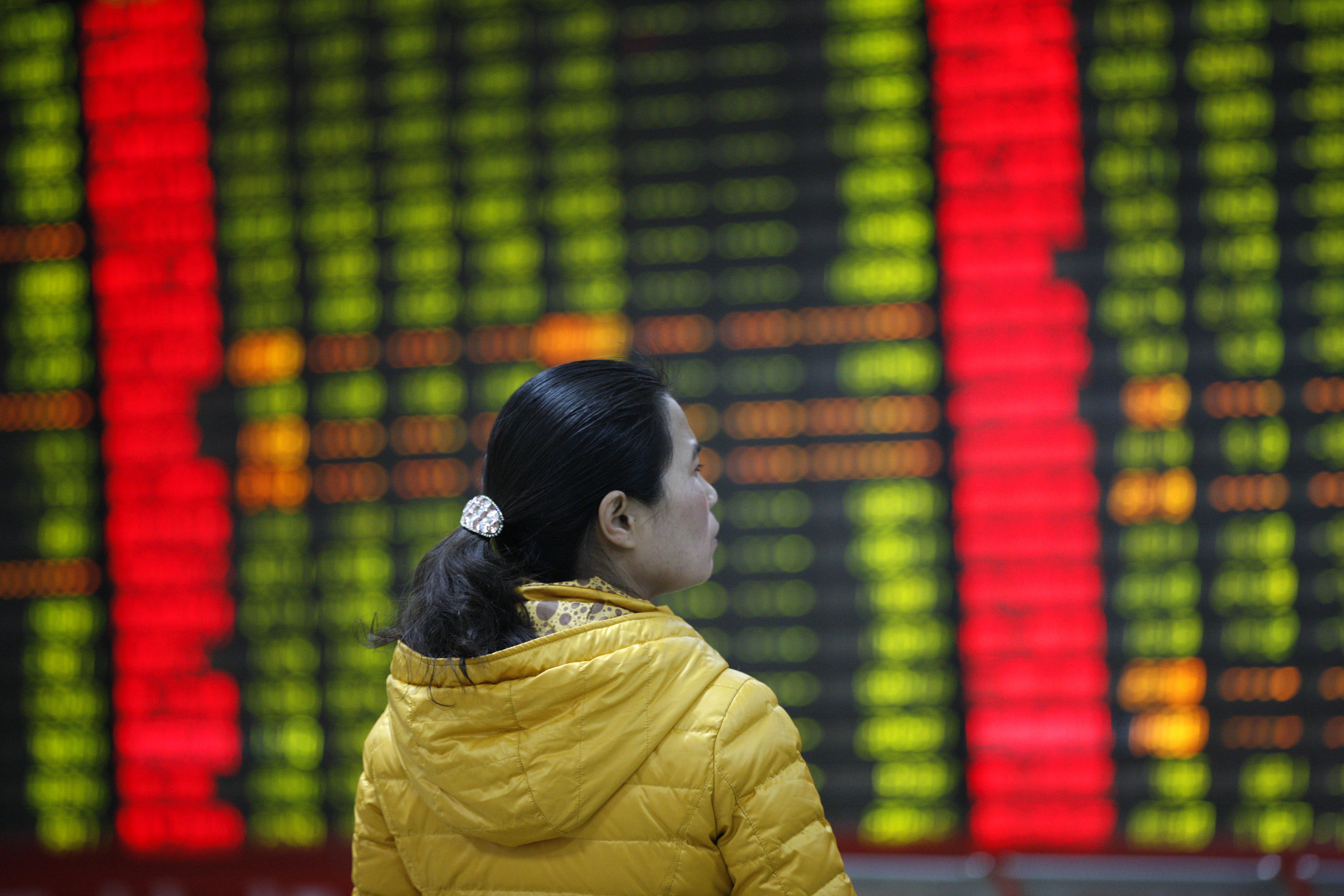 An investor watches electric board in a stock market in Huaibei, Anhui province, east China on Jan. 7, 2016.