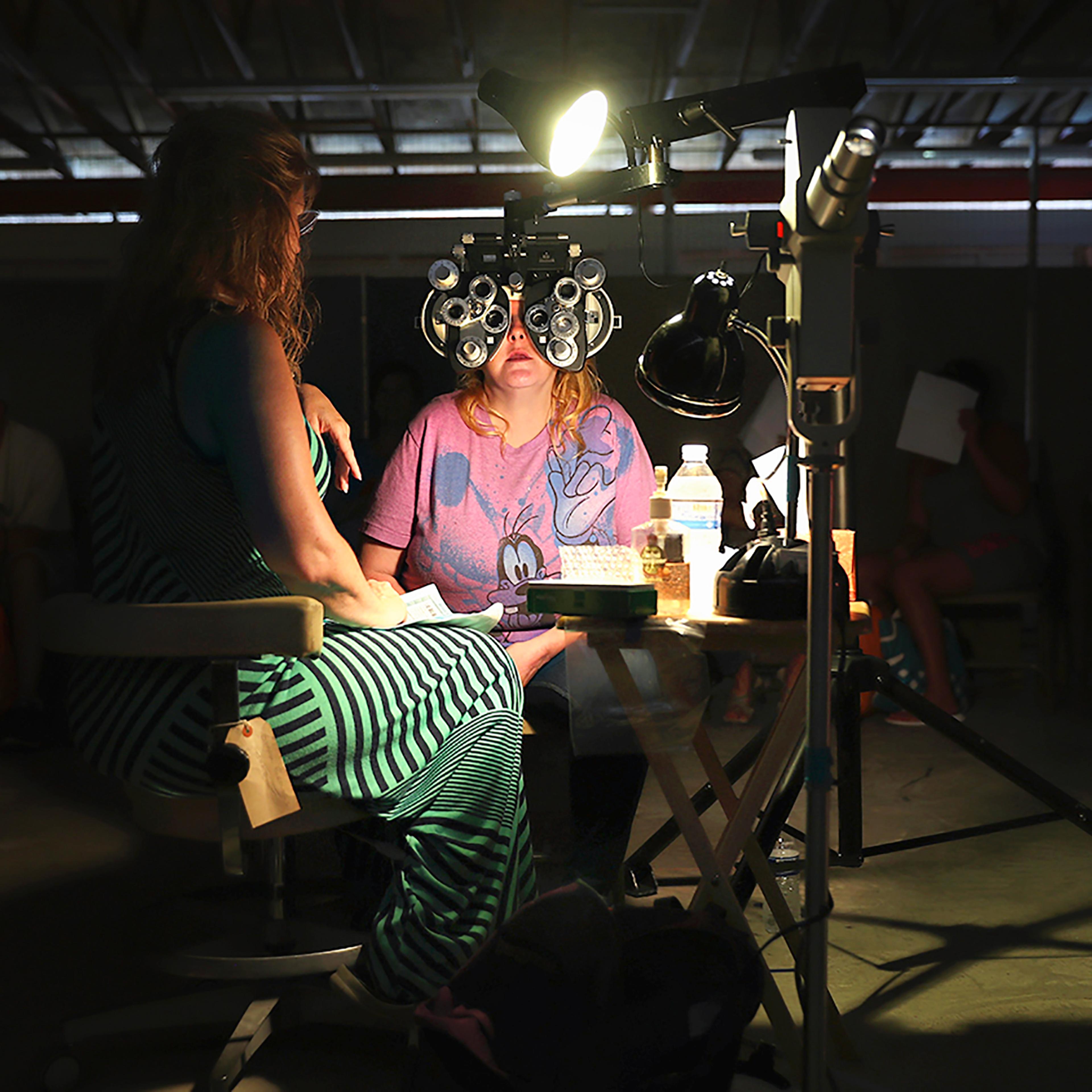 A volunteer checks a patient's vision at the Remote Area Medical (RAM), mobile clinic on July 21, 2017 in Wise, Va.
