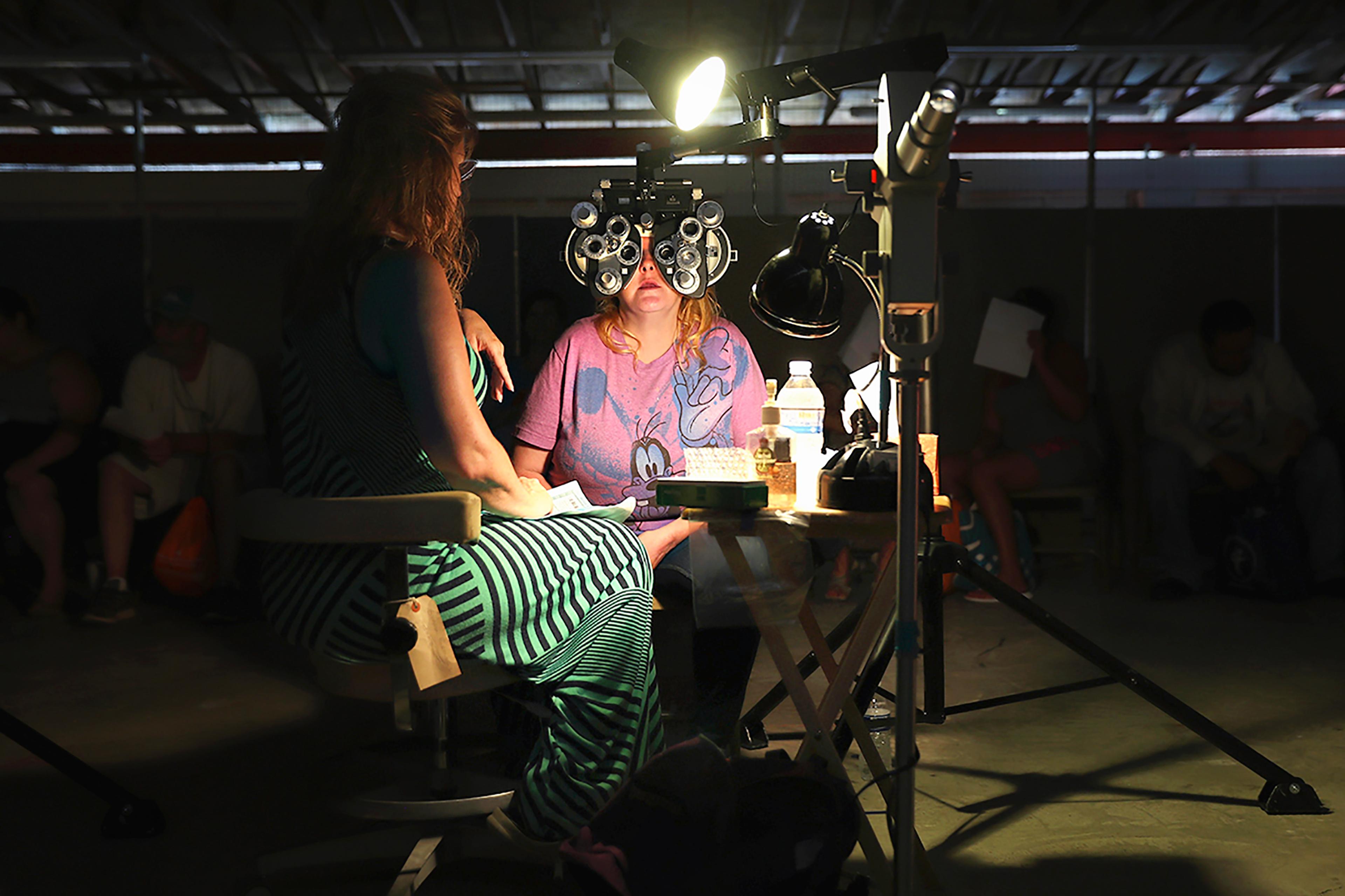 A volunteer checks a patient's vision at the Remote Area Medical (RAM), mobile clinic on July 21, 2017 in Wise, Va.