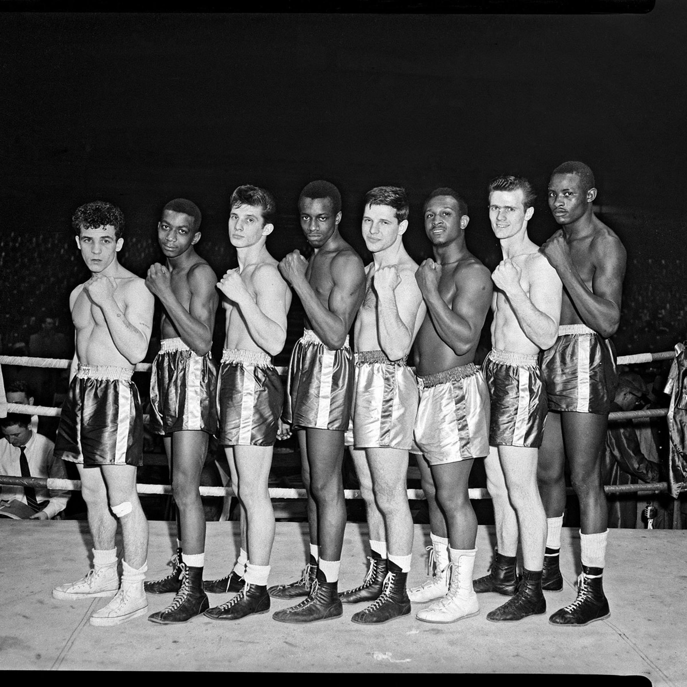 Boxers, possibly Golden Gloves contenders, line up in a boxing ring, 1955.