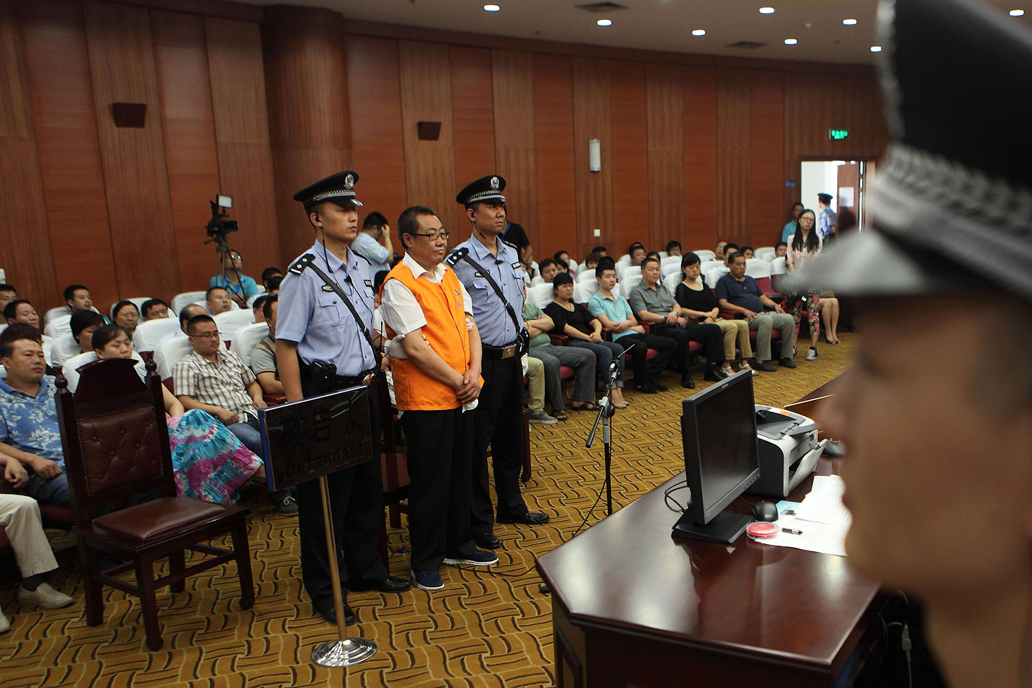 Yang Dacai (2nd L standing), a Chinese official branded 'Brother Watch' because of his expensive taste in timepieces, stands in the courtroom in the Intermediate people's court of Xian, northwest China's Shaanxi province on Sept. 5, 2013