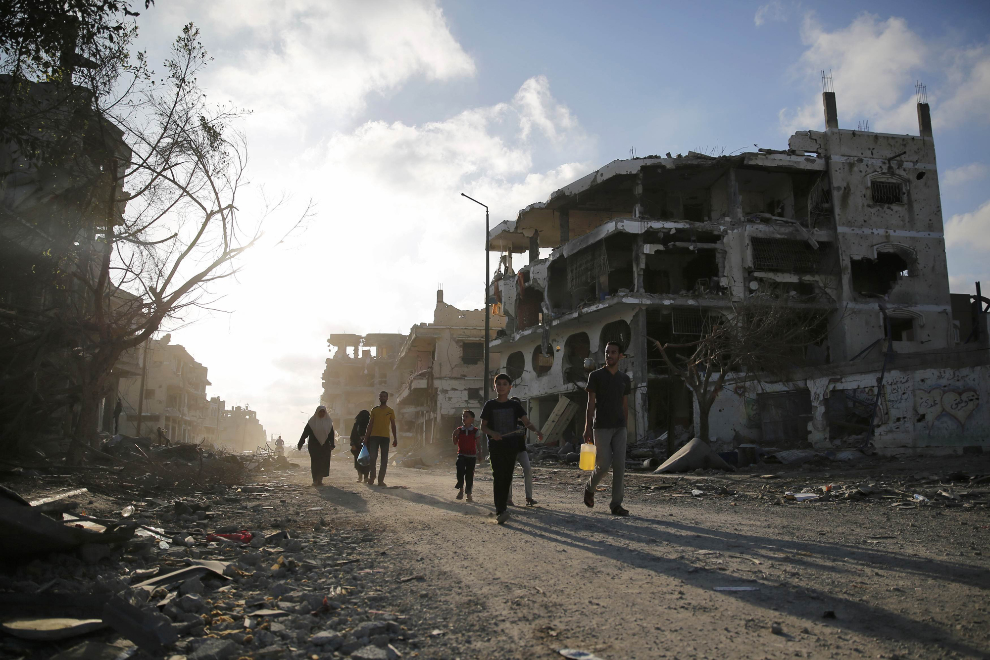 Palestinians walk amid the ruins of destroyed homes in the Shujayeh neighborhood, which witnesses said was heavily hit by Israeli shelling and air strikes during an Israeli offensive, east of Gaza City, Aug. 6, 2014.