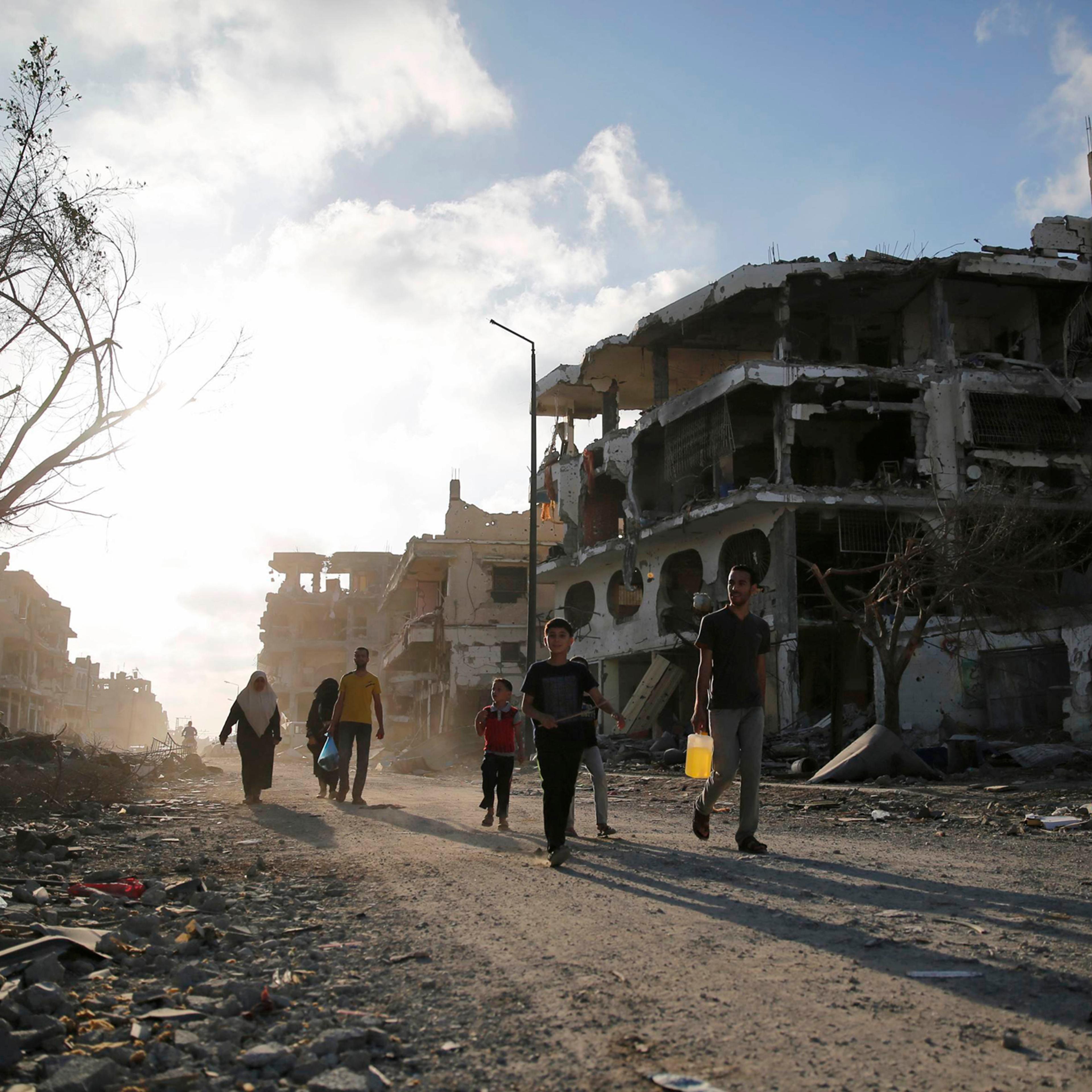 Palestinians walk amid the ruins of destroyed homes in the Shujayeh neighborhood, which witnesses said was heavily hit by Israeli shelling and air strikes during an Israeli offensive, east of Gaza City, Aug. 6, 2014.
