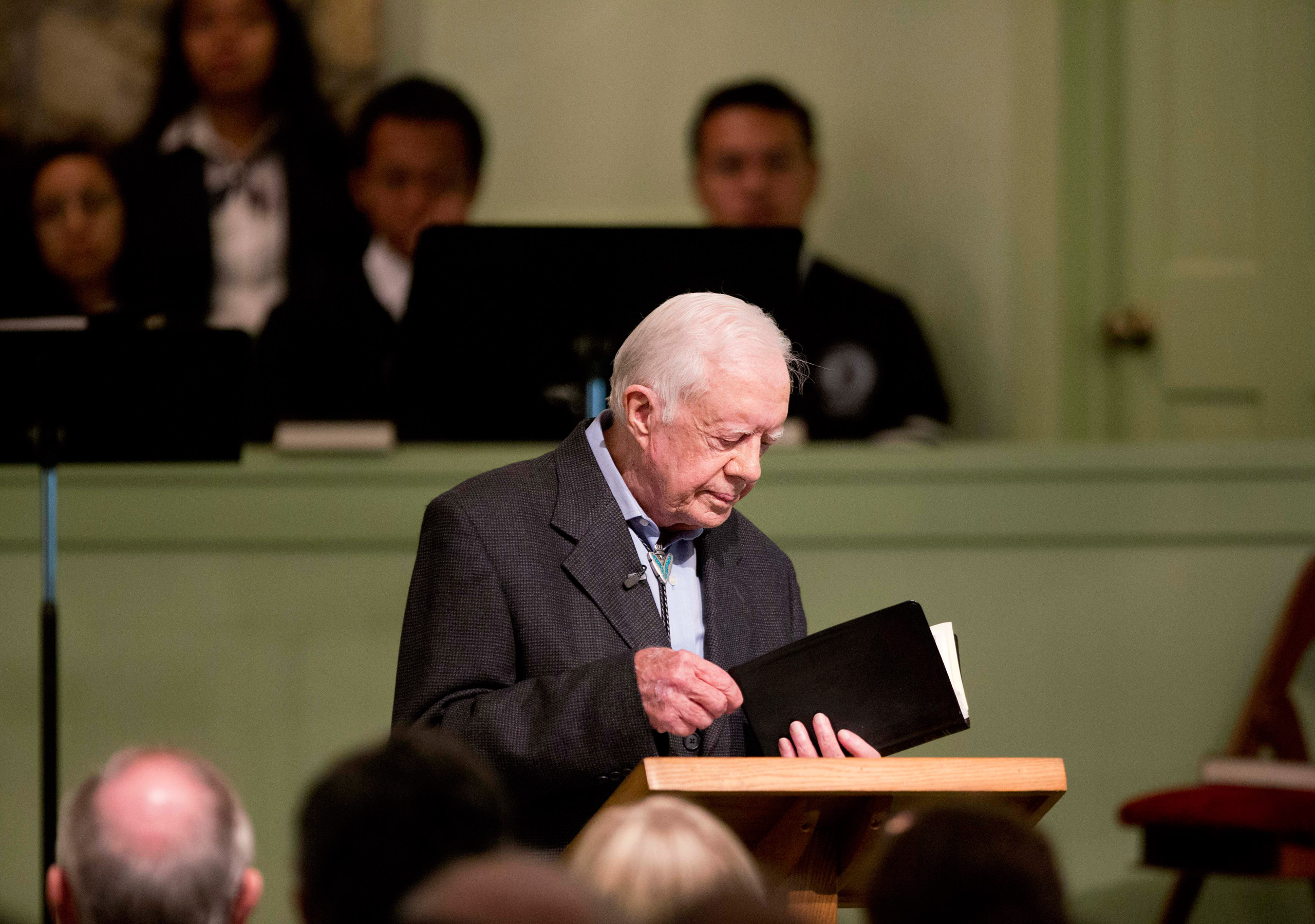 Former President Jimmy Carter opens up a Bible while teaching Sunday School class at Maranatha Baptist Church in his hometown Sunday, Aug. 23, 2015, in Plains, Ga. The 90-year-old Carter gave one lesson to about 300 people filling the small Baptist churc