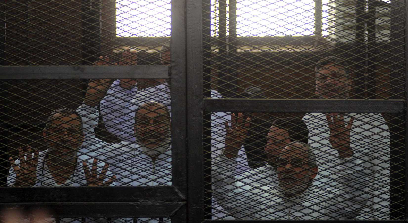Muslim Brotherhood Leader Mohamed Badie (R) and 47 other defendants stand behind bars during the trial of Brotherhood members at a courtroom on March 6, 2014 in Cairo, Egypt.