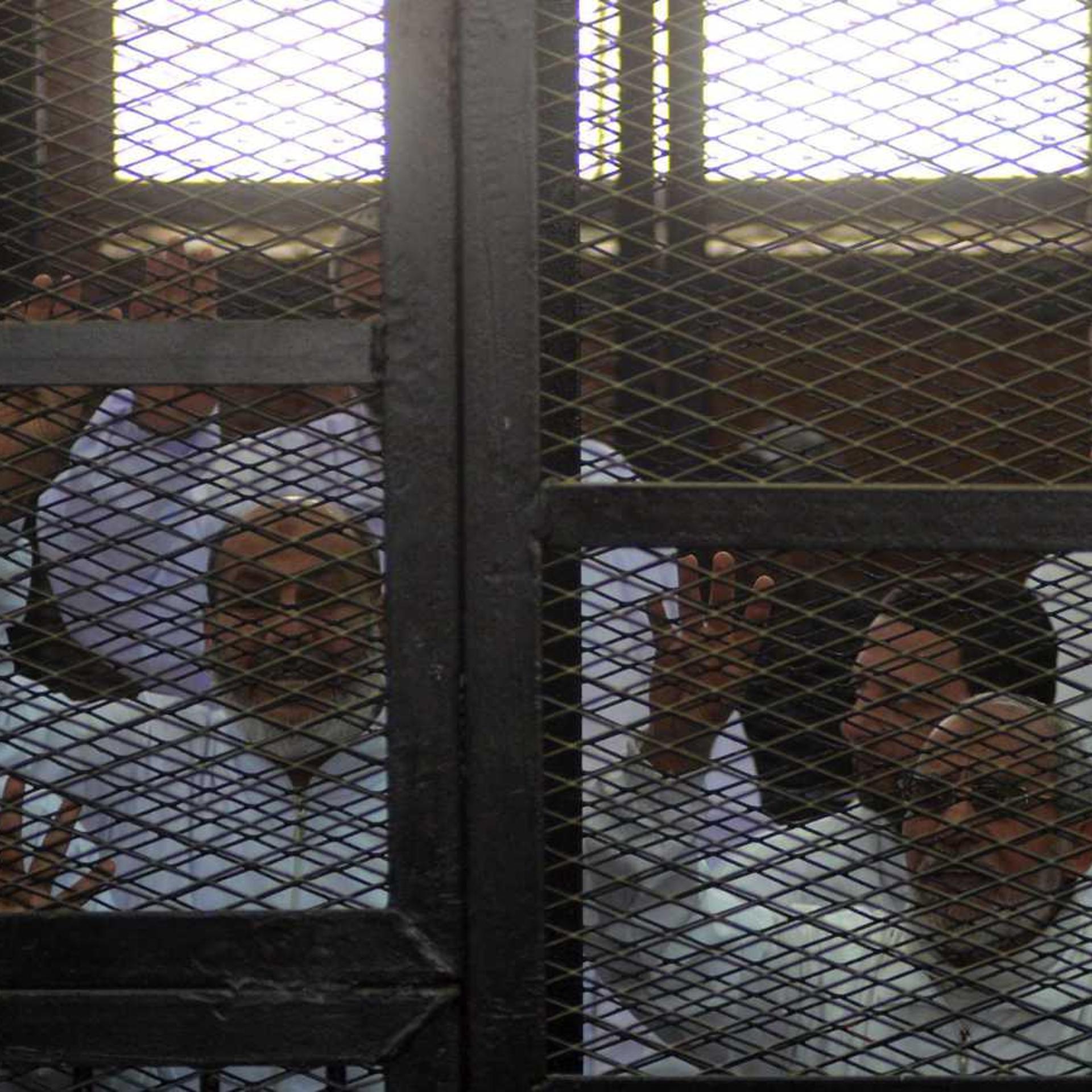 Muslim Brotherhood Leader Mohamed Badie (R) and 47 other defendants stand behind bars during the trial of Brotherhood members at a courtroom on March 6, 2014 in Cairo, Egypt.