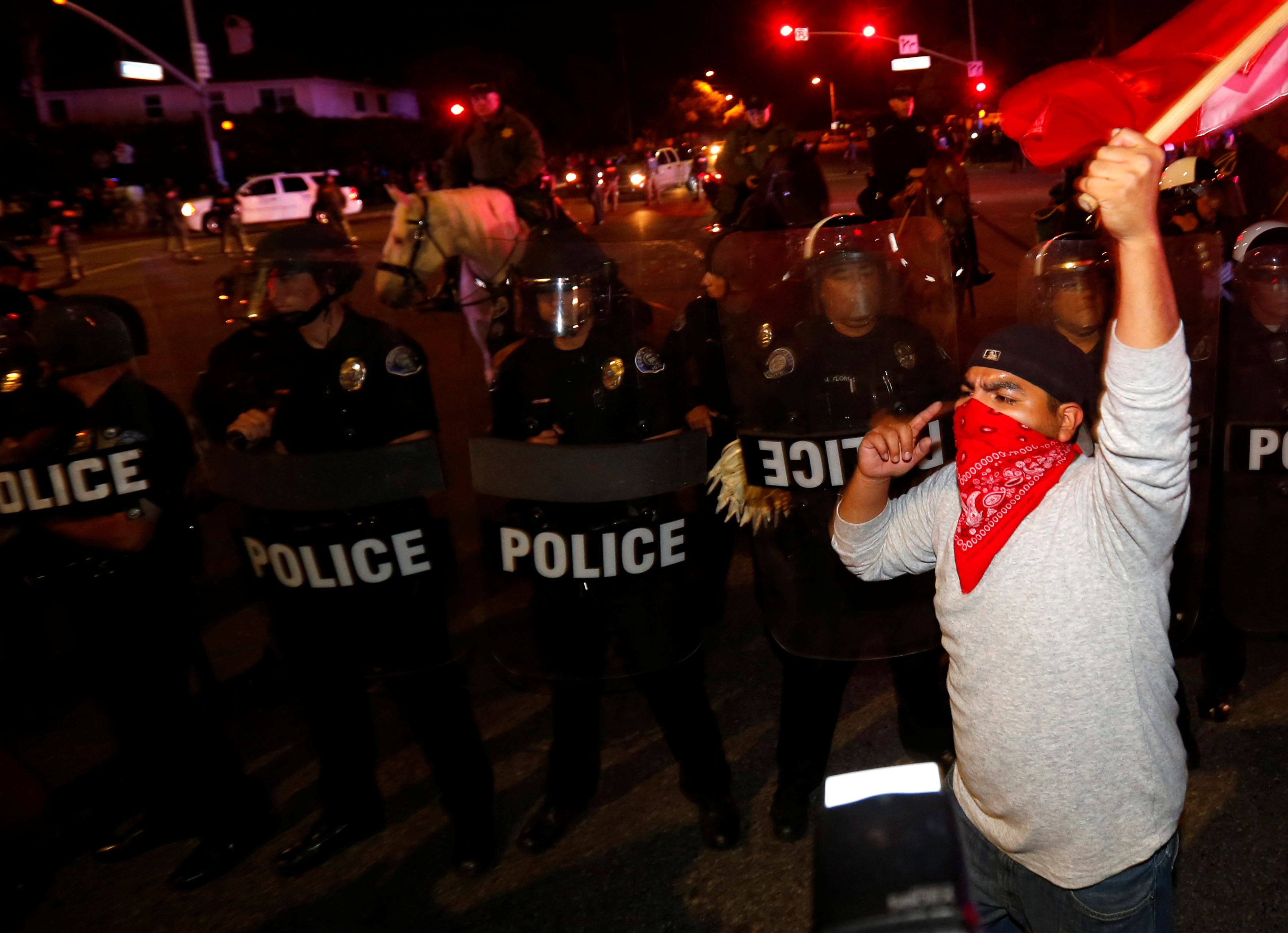 Police in riot gear form a line to break up a group of protesters outside Republican U.S. presidential candidate Donald Trump's campaign rally in Costa Mesa