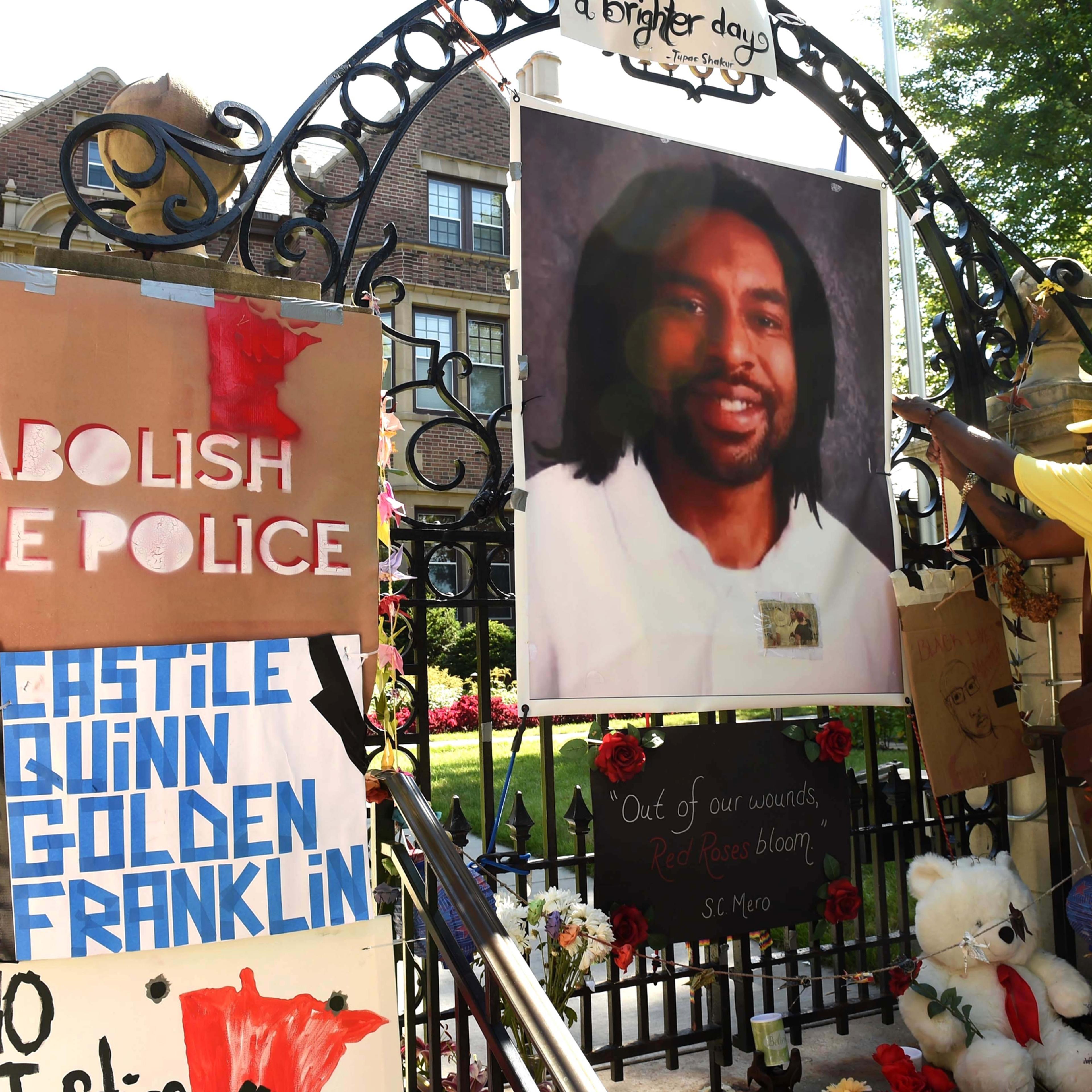 FILE - In this Sunday, July 24, 2016, file photo, King Demetrius Pendleton hangs a sign on the gate of the Governor's Residence in St. Paul, Minn., as protesters demonstrate against the July 6 shooting death of Philando Castile by a St. Anthony police of