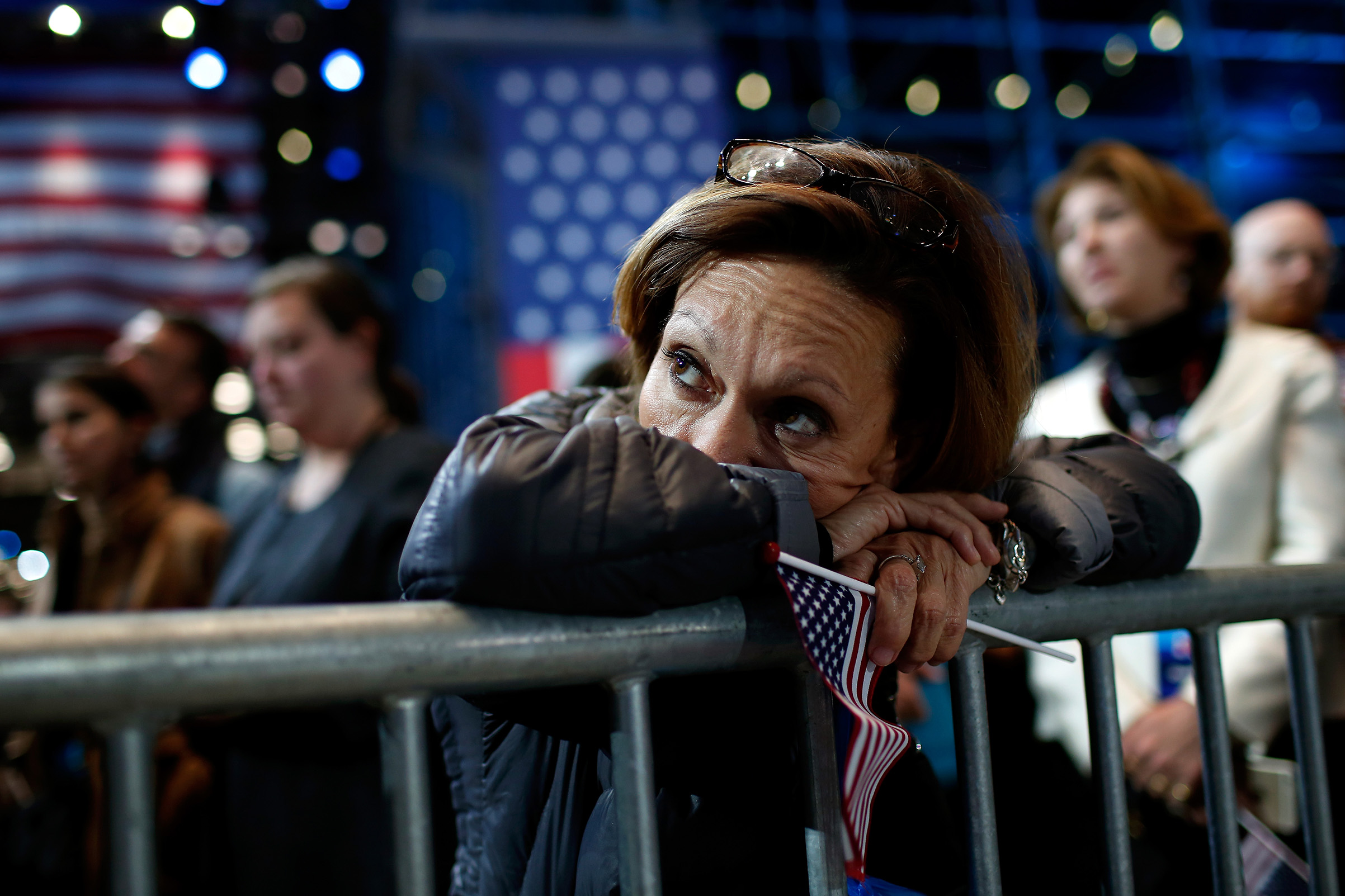 A woman holds an American flag as she watches the voting results at Democratic presidential nominee Hillary Clinton's