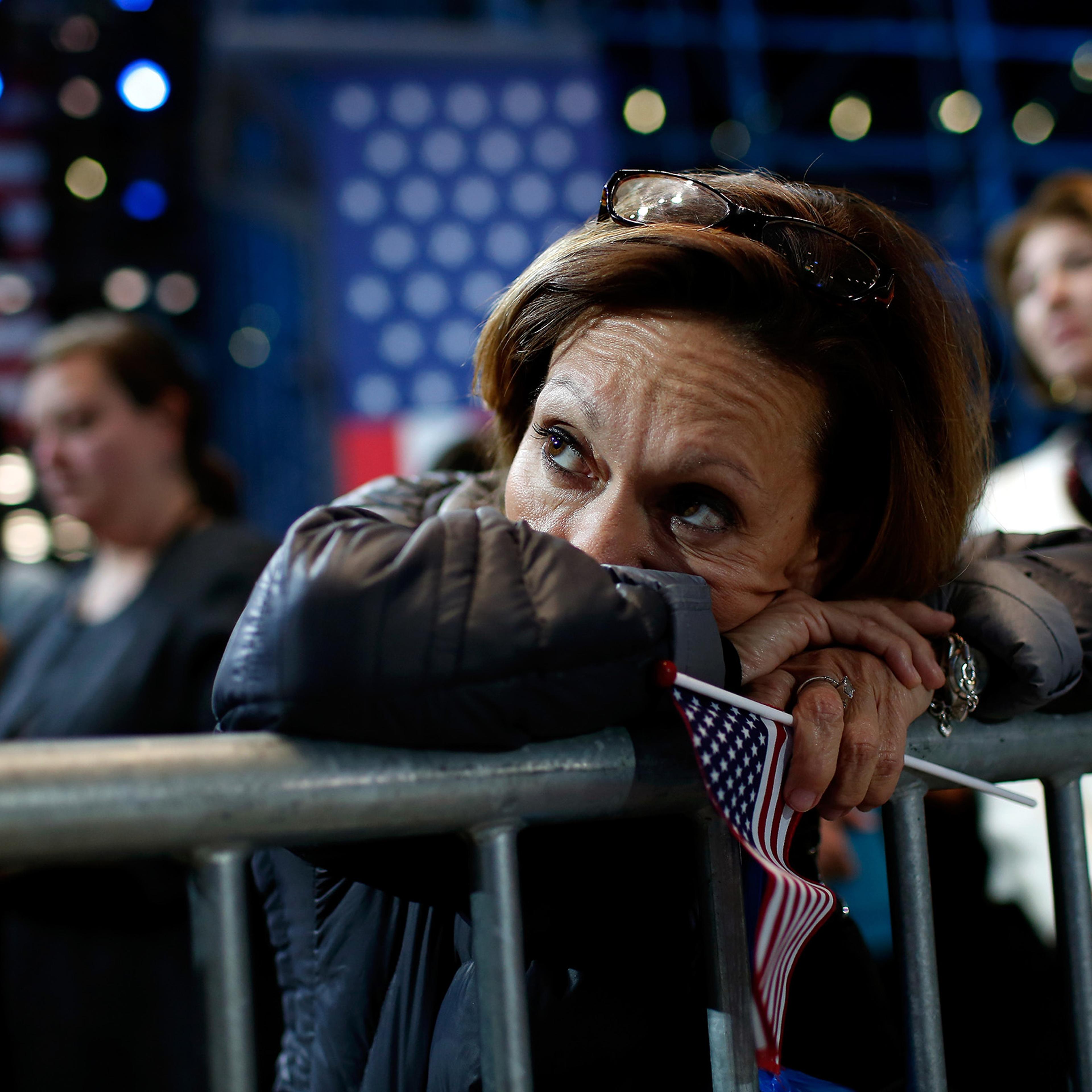 A woman holds an American flag as she watches the voting results at Democratic presidential nominee Hillary Clinton's