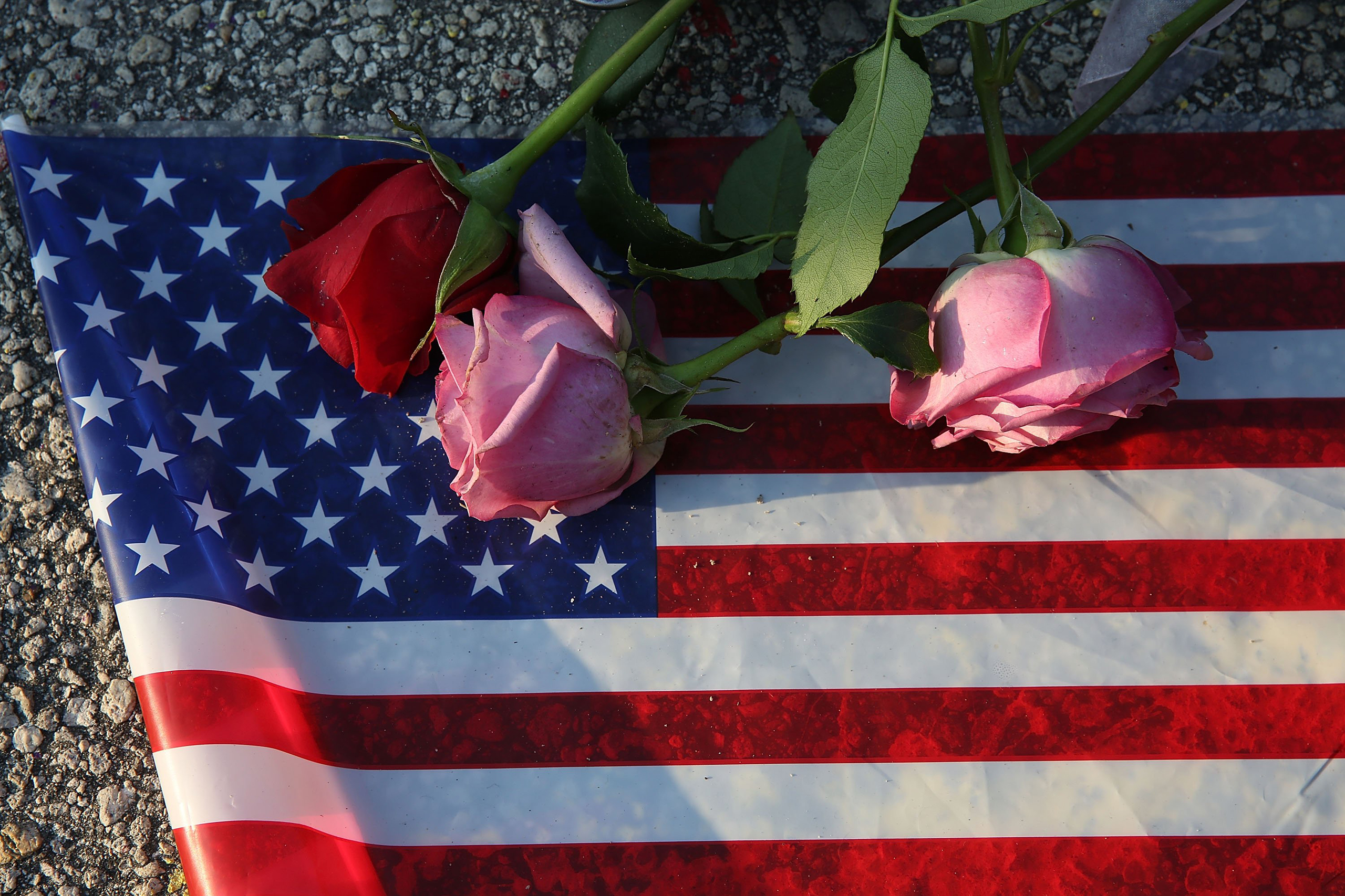 Flowers and an American flag are seen on the ground near the Pulse Nightclub where Omar Mateen allegedly killed at least 50 people in Orlando on June 13, 2016.