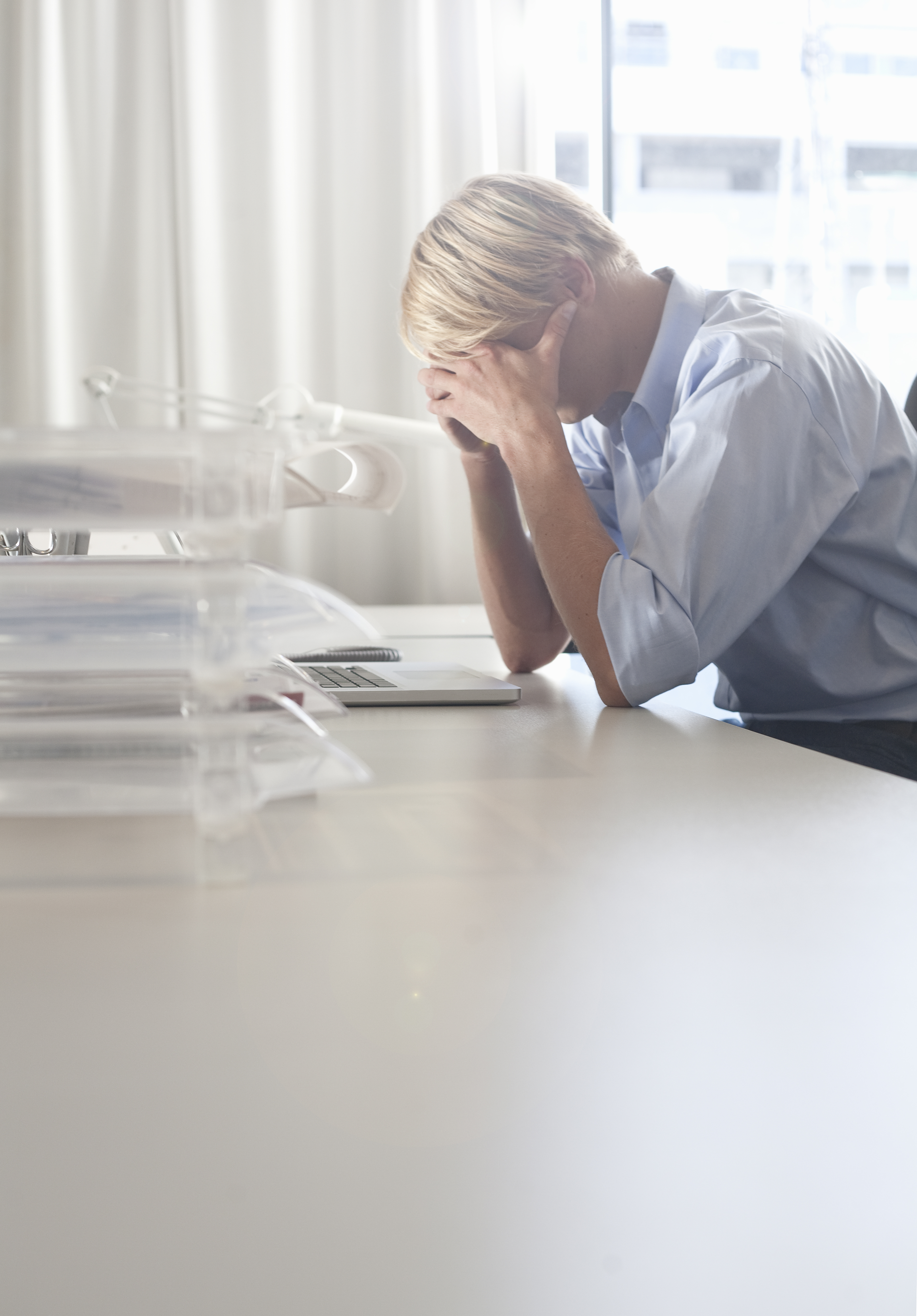 Businessman holding his head at desk