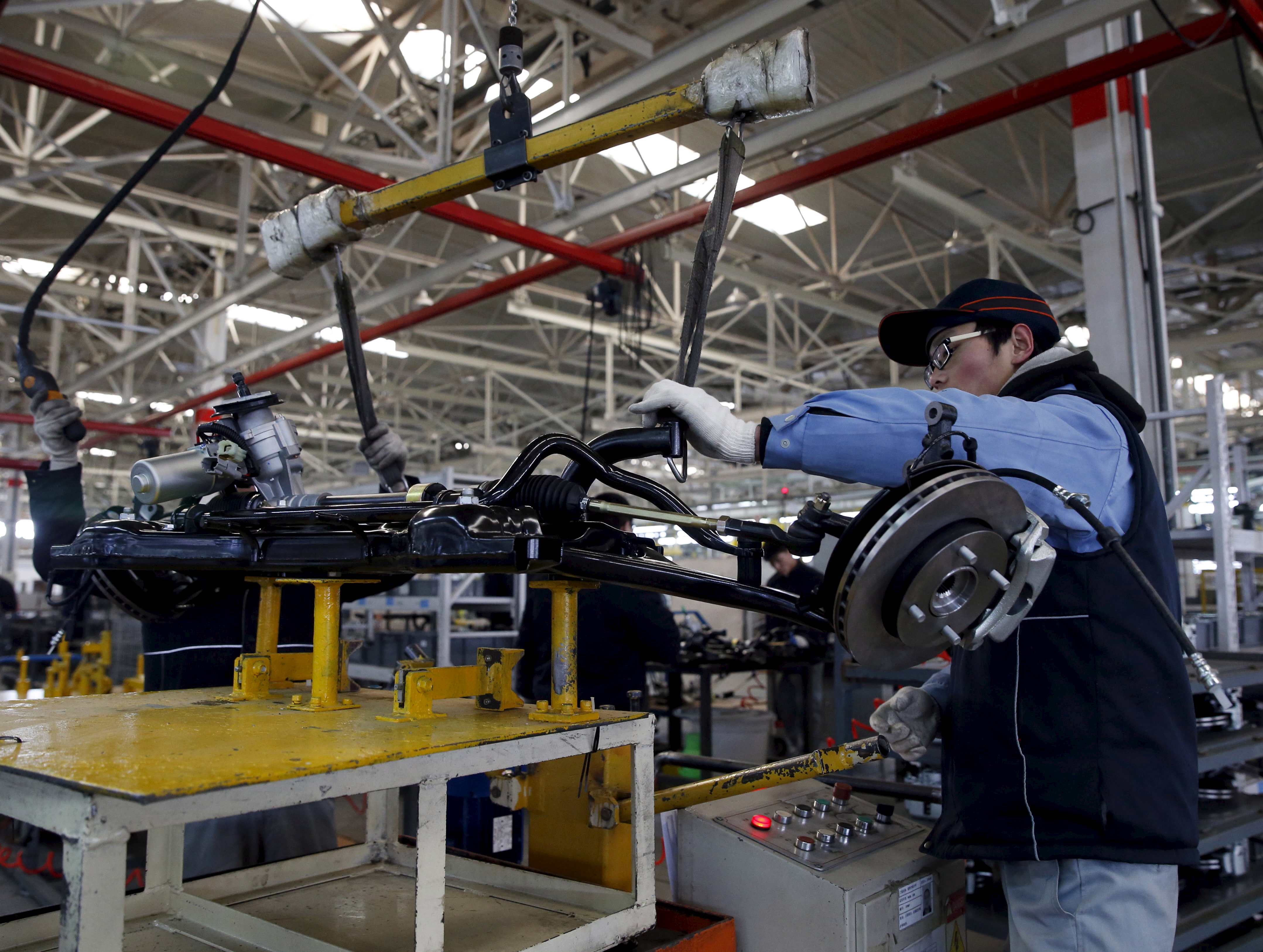 An employee works on an assembly line producing electronic cars at a factory of Beijing Electric Vehicle, funded by BAIC Group, in Beijing