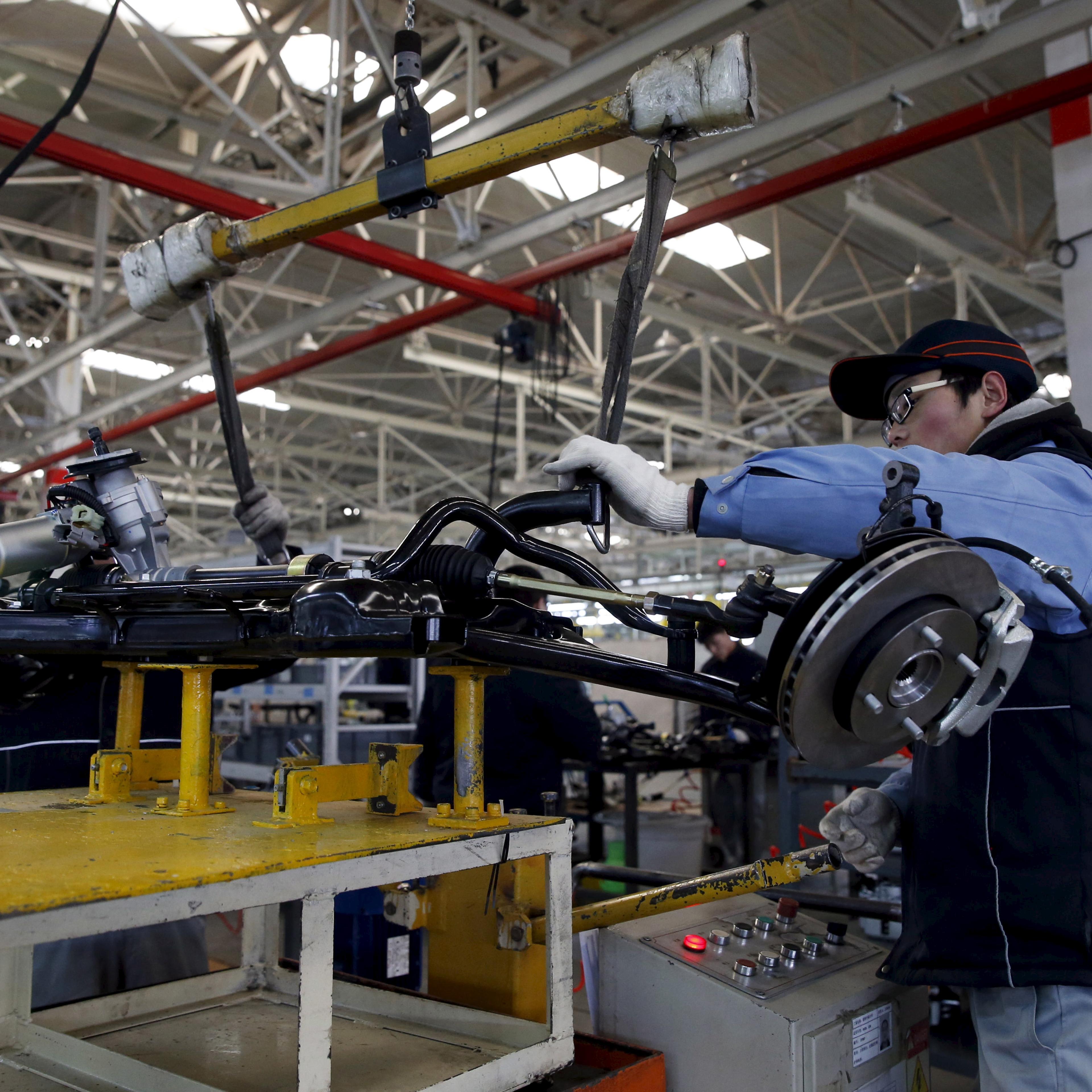 An employee works on an assembly line producing electronic cars at a factory of Beijing Electric Vehicle, funded by BAIC Group, in Beijing