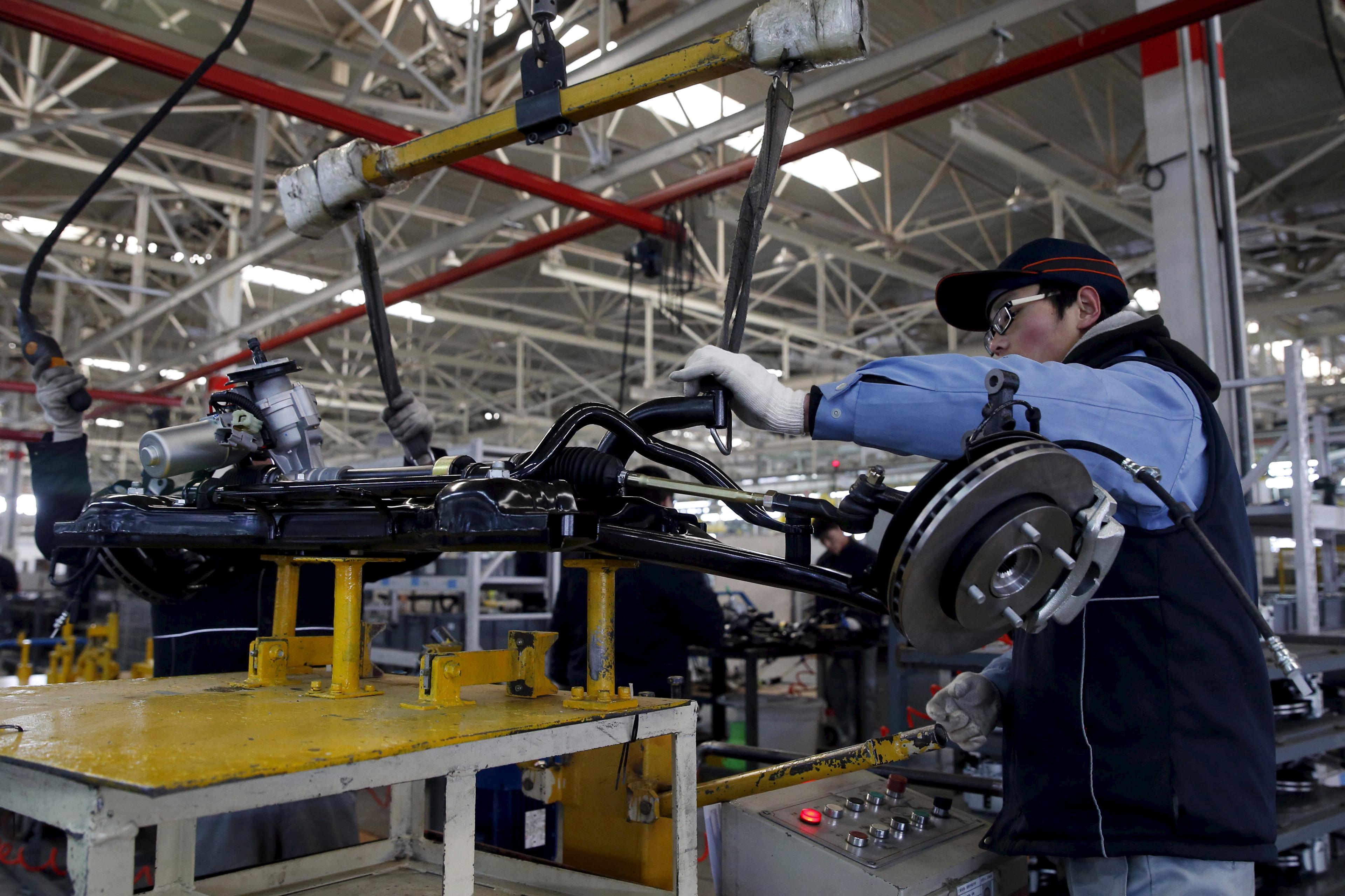 An employee works on an assembly line producing electronic cars at a factory of Beijing Electric Vehicle, funded by BAIC Group, in Beijing