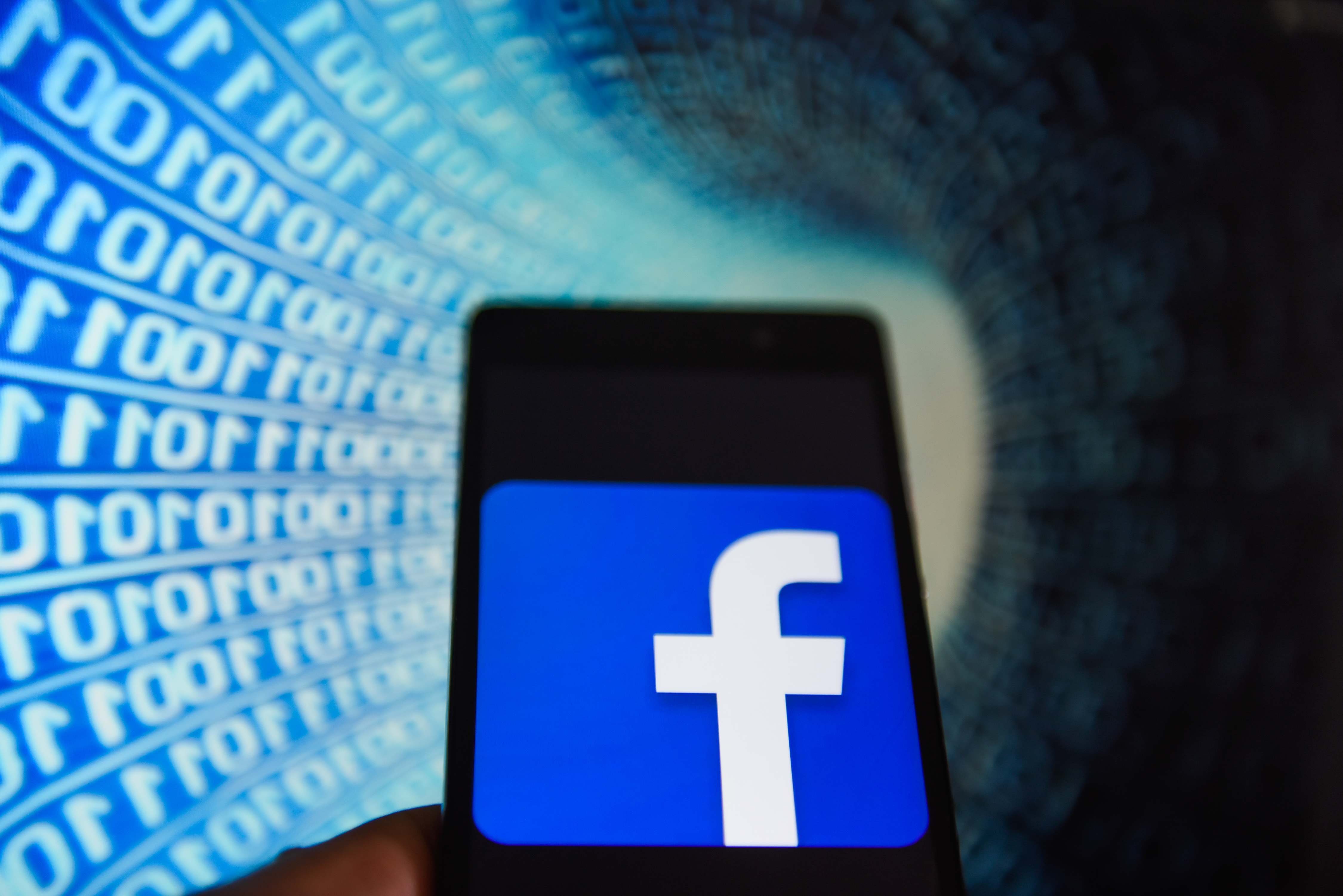 Facebook logo is seen in an Android mobile with binary