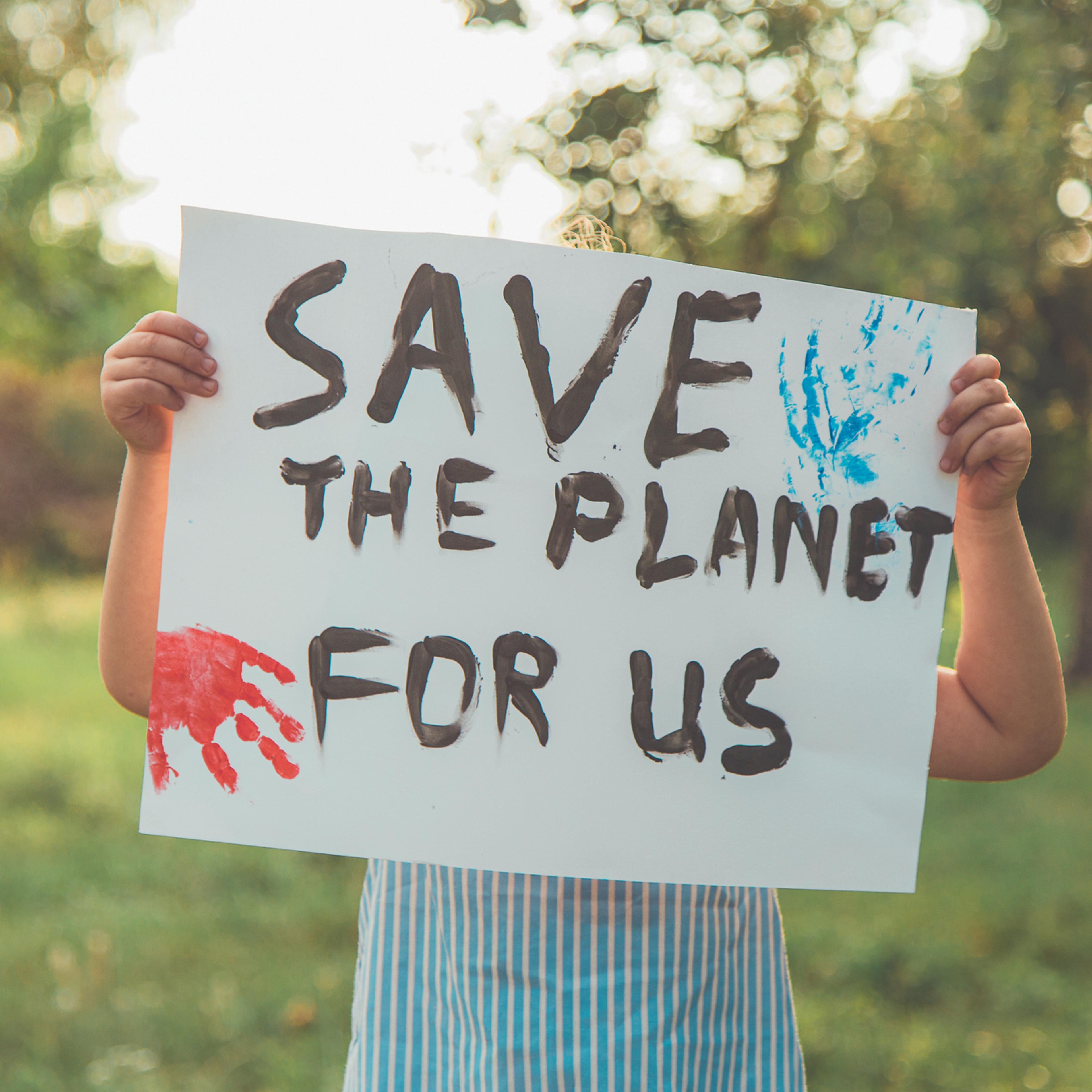 Kid with posters protecting the planet. Protest